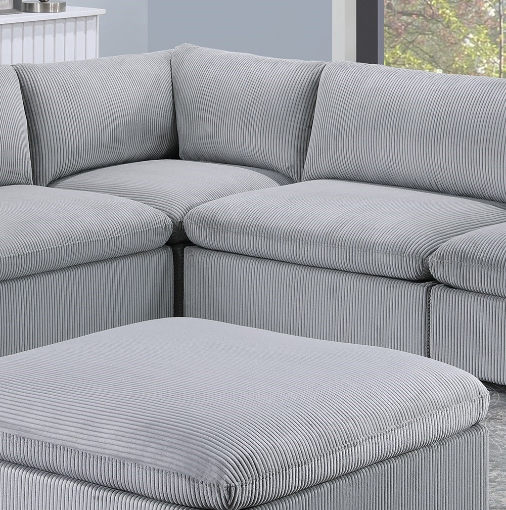 Gray corduroy sectional sofa with plush cushions and matching ottoman