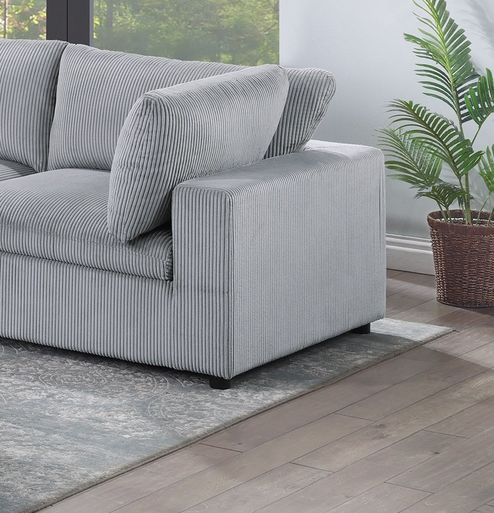 Closeup of plush gray corduroy sofa armrest with textured fabric