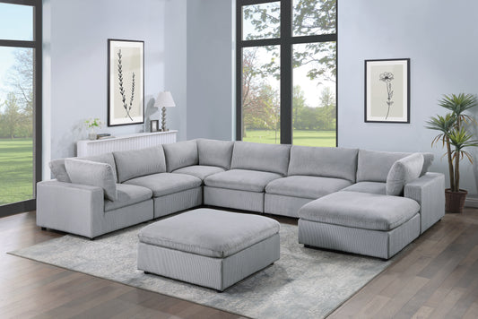 Light grey corduroy sectional sofa with matching ottoman on a patterned rug