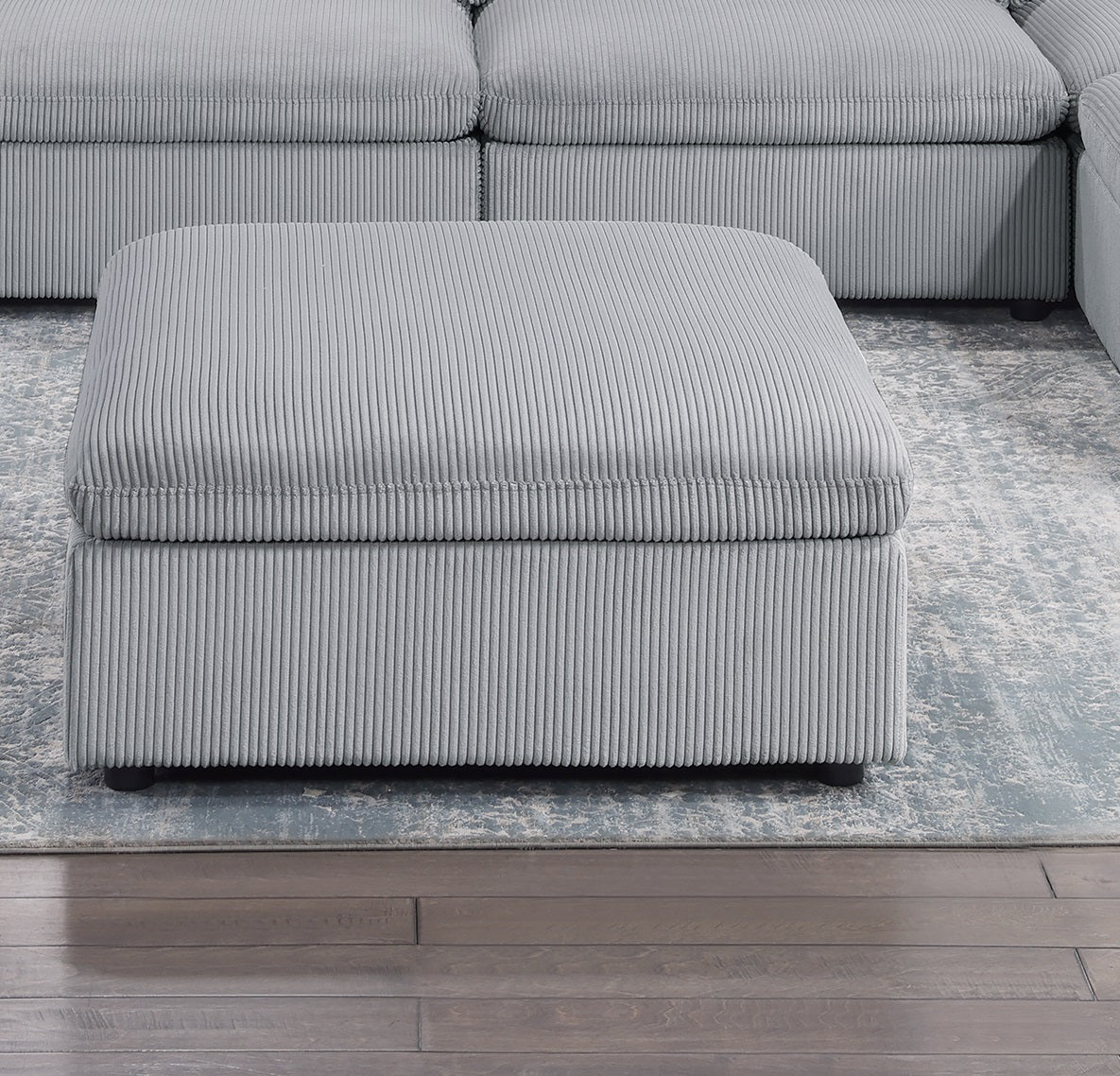Plush grey corduroy ottoman with storage complementing modern living room decor