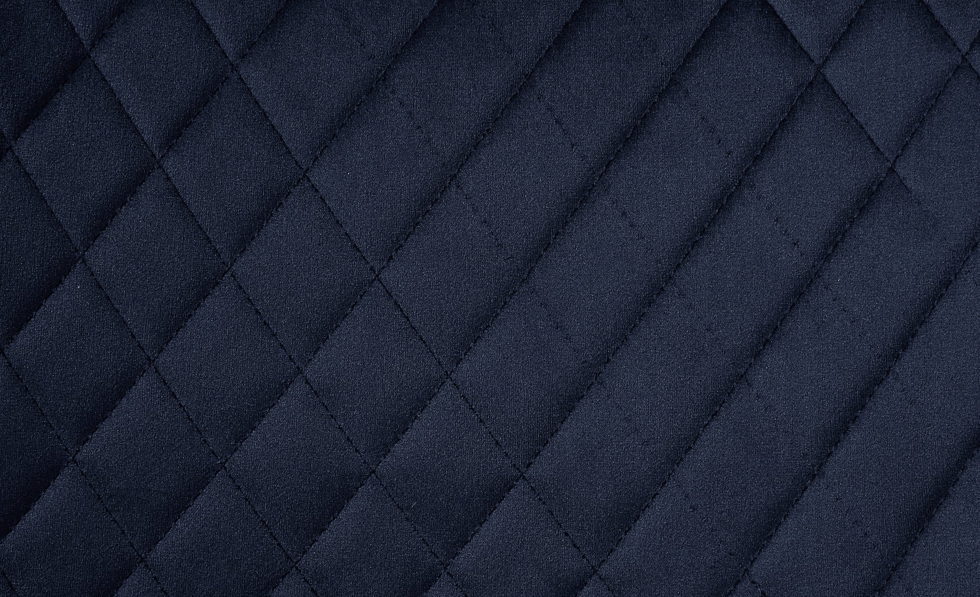 Dark navy quilted fabric texture with diamond stitching