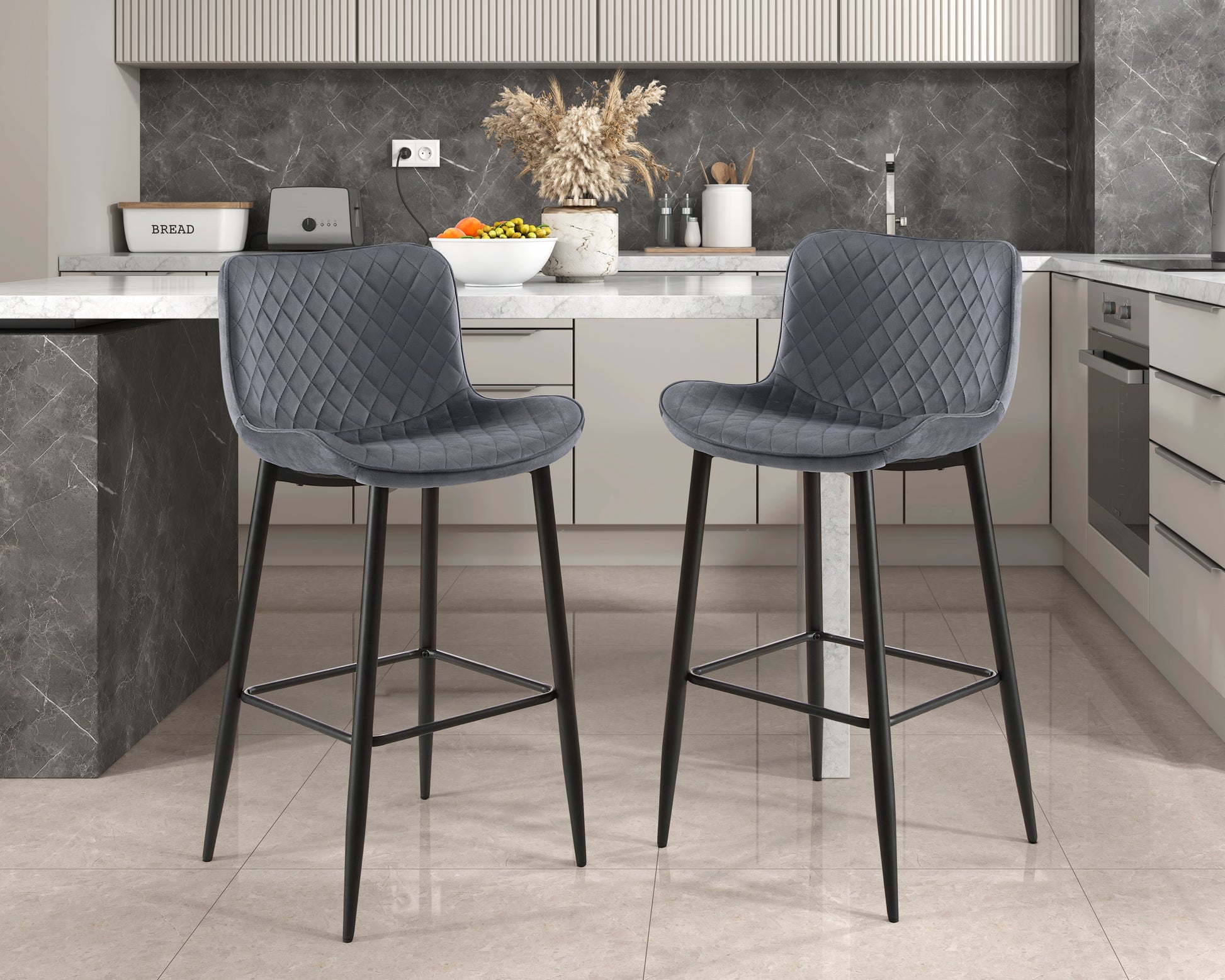 Two plush grey velvet bar stools with diamond tufting and black metal legs
