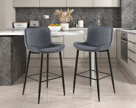 Two plush grey velvet bar stools with diamond tufting and black metal legs