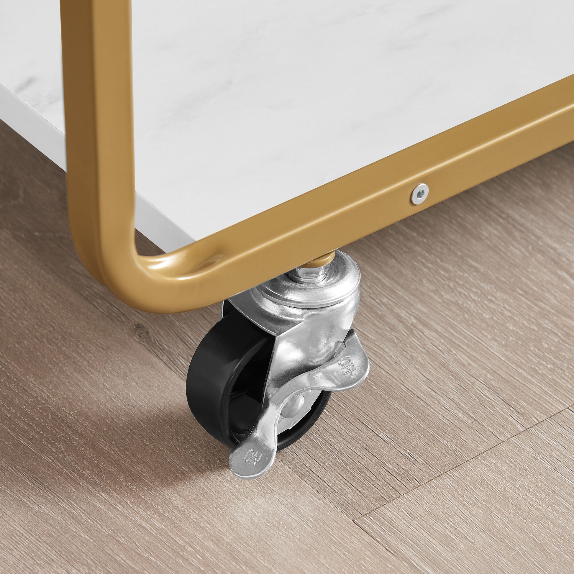 Goldfinished metal frame with a black caster wheel