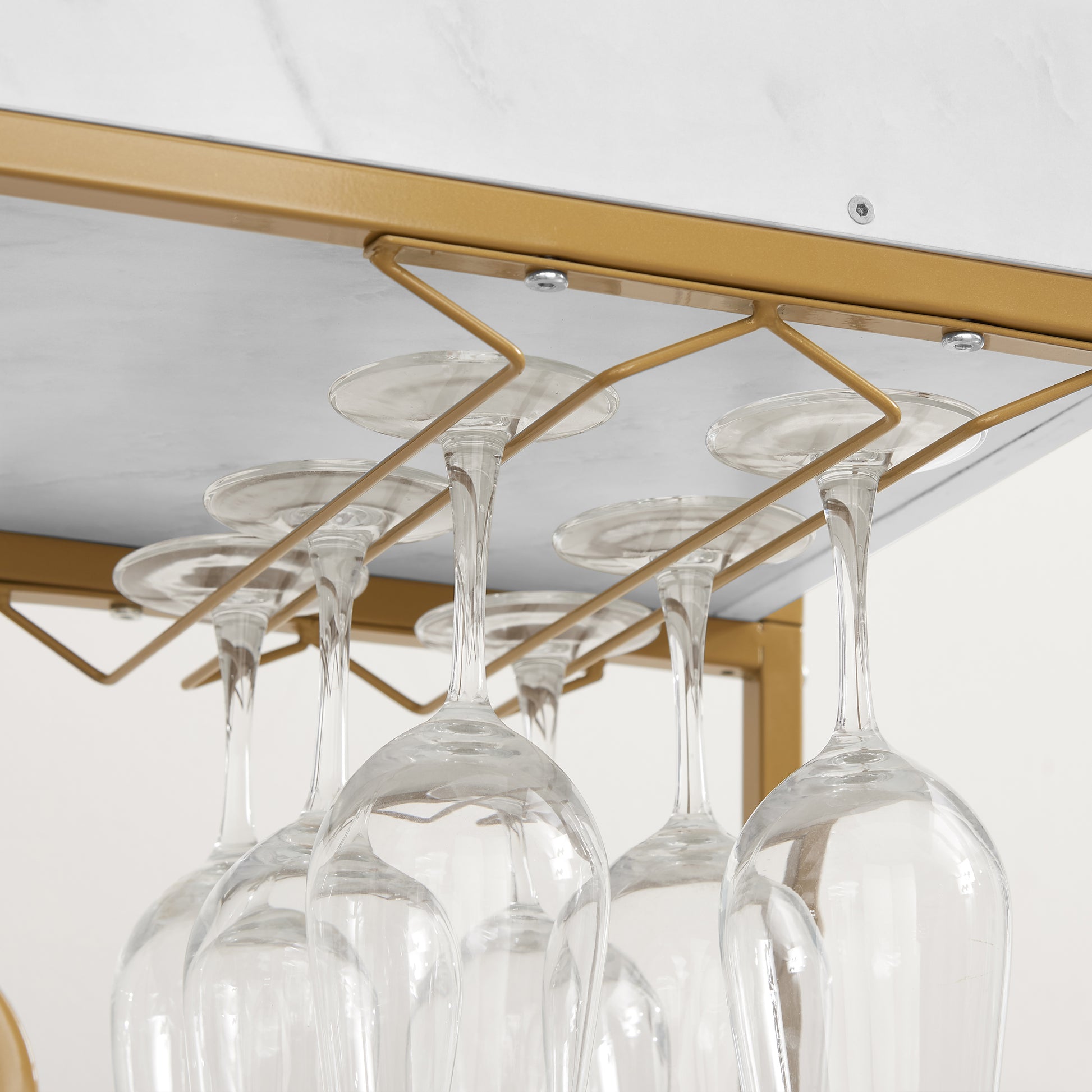 Gold metal wine glass rack holding multiple clear wine glasses upside down