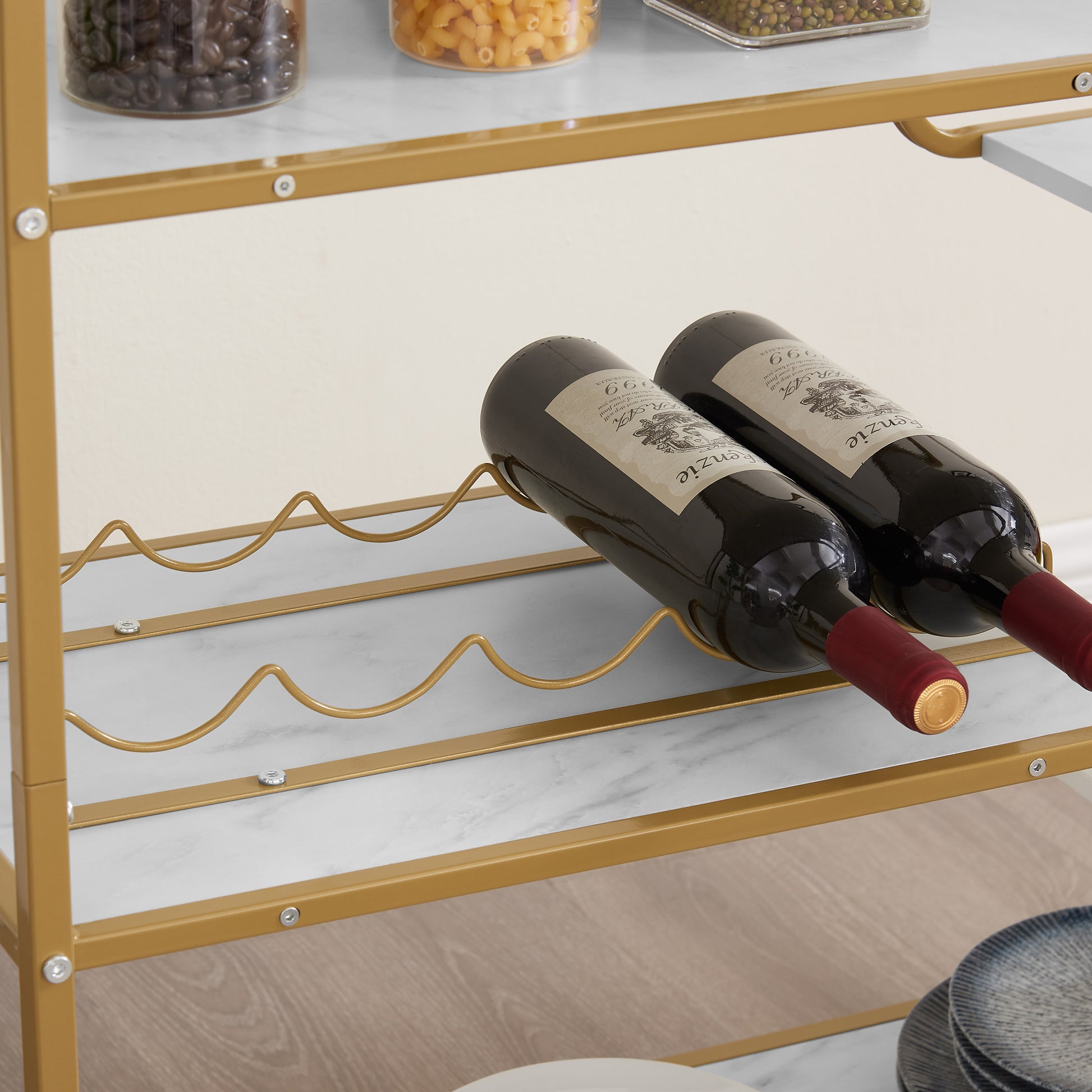 Gold metal wine rack holding two bottles of red wine