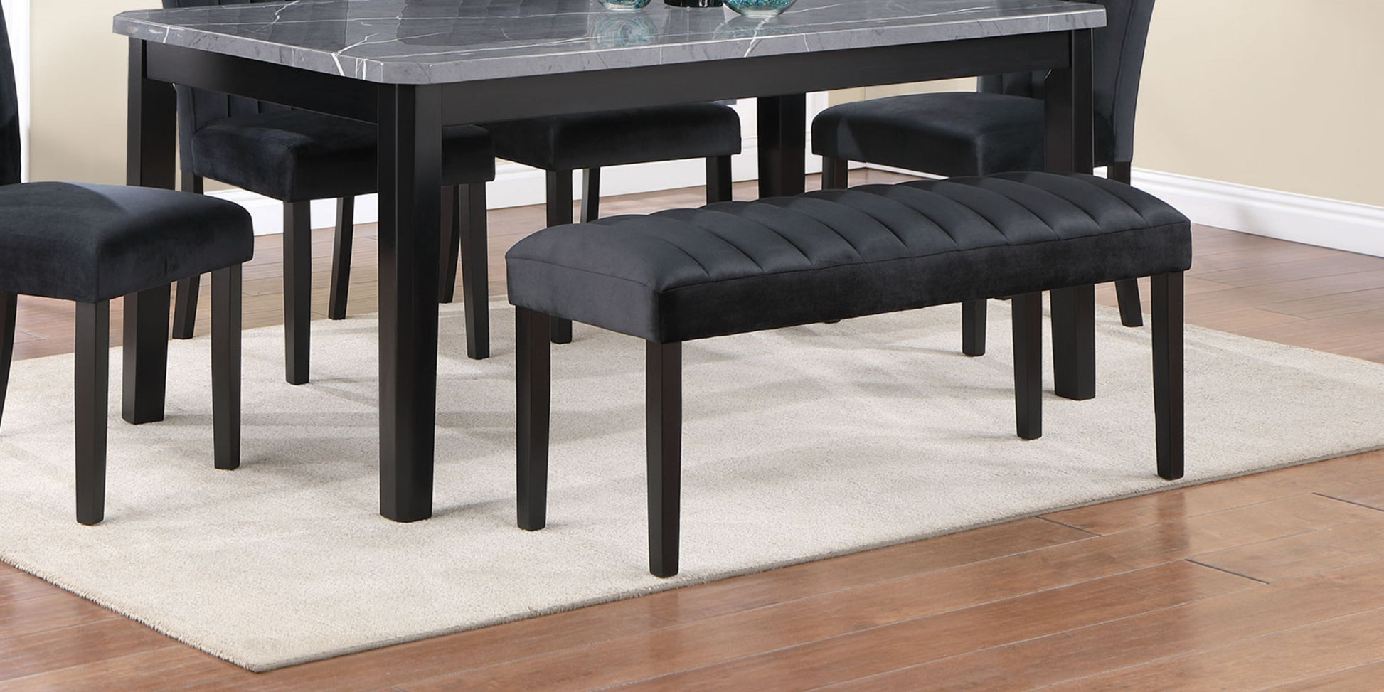 Tufted black velvet dining bench with black wooden legs complements modern dining sets