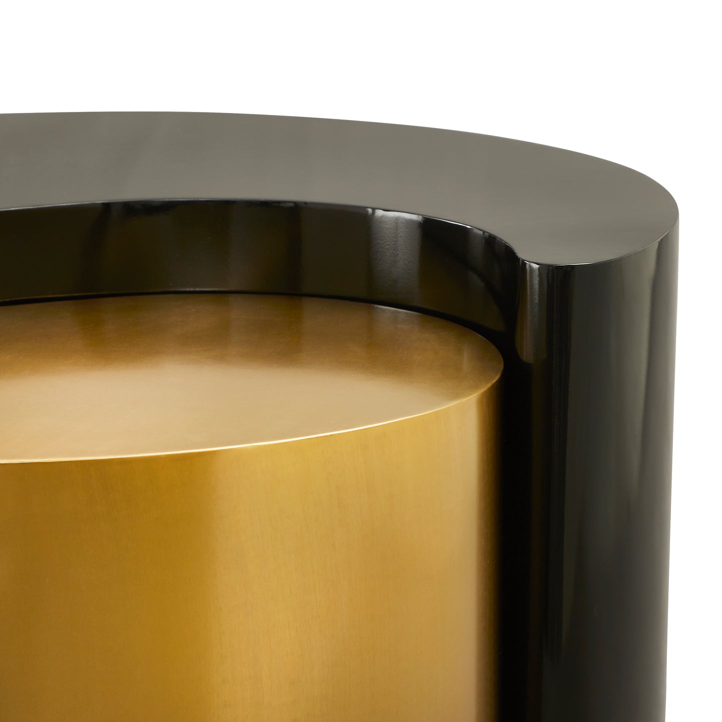 Closeup of a modern cylindrical side table with a glossy black exterior and a brushed gold interior