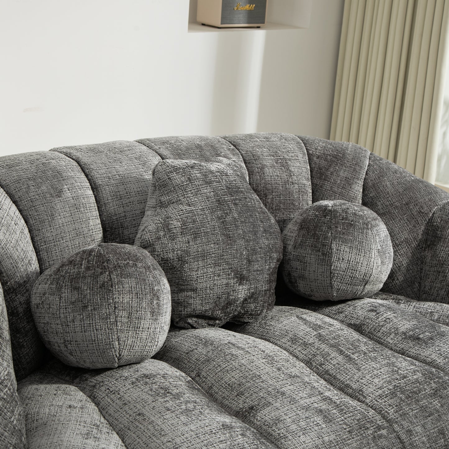 Closeup of a charcoal gray textured sofa with plush accent pillows