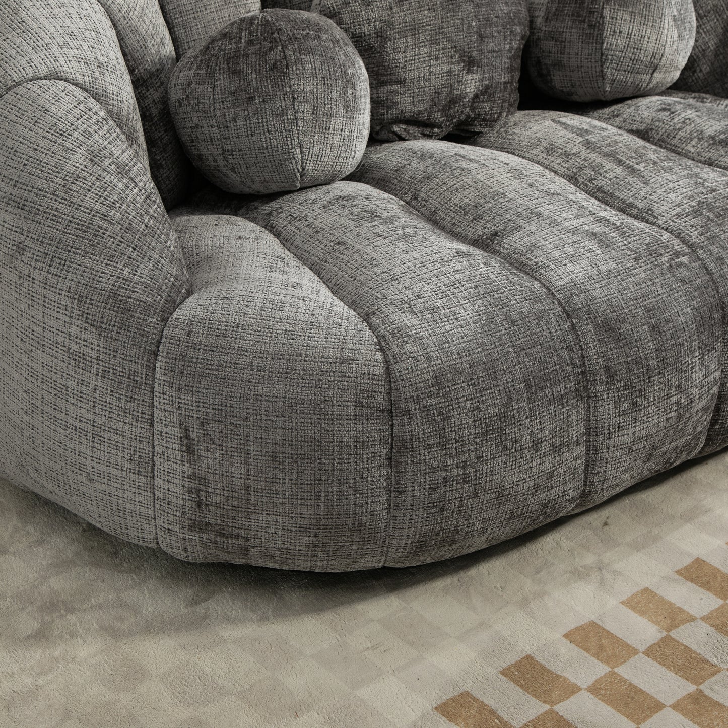 Plush grey velvet sofa with rounded armrests and textured cushions designed for ultimate comfort