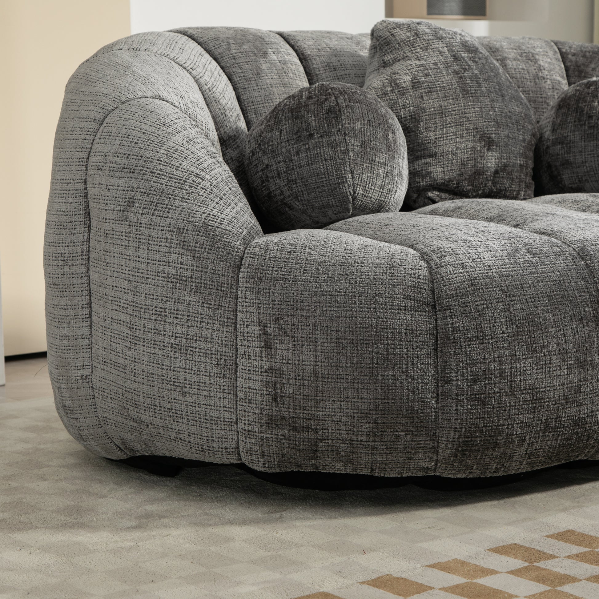 Textured grey fabric sofa with plush cushions and a rounded silhouette