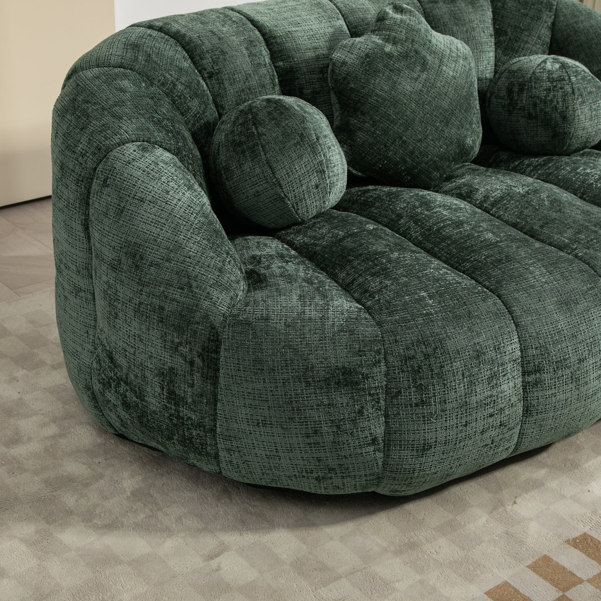 Dark green velvet sofa with plush rounded cushions and channeled upholstery