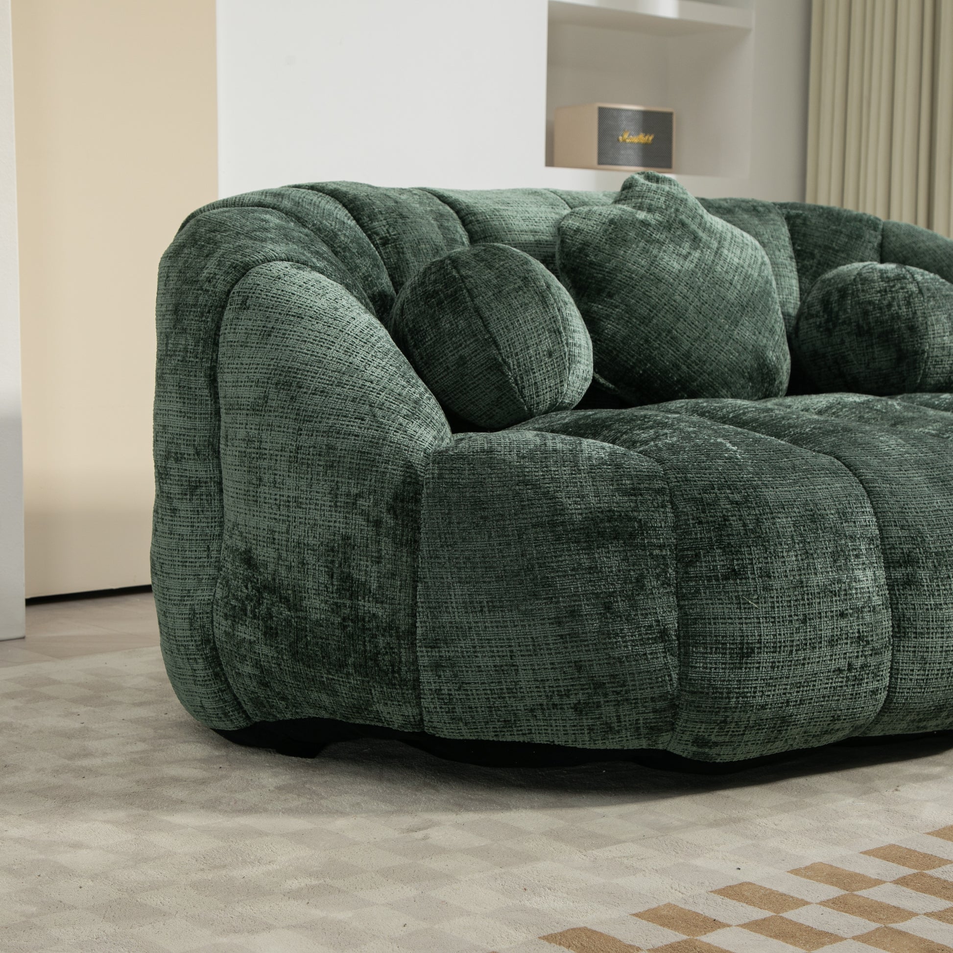 Plush emerald green velvet sofa with deep channel tufting and round accent pillows