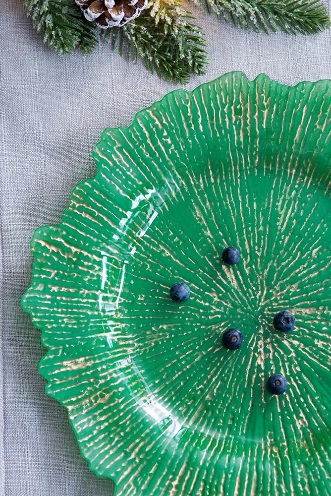 Emerald green glass charger plate with golden textured design perfect for festive table settings