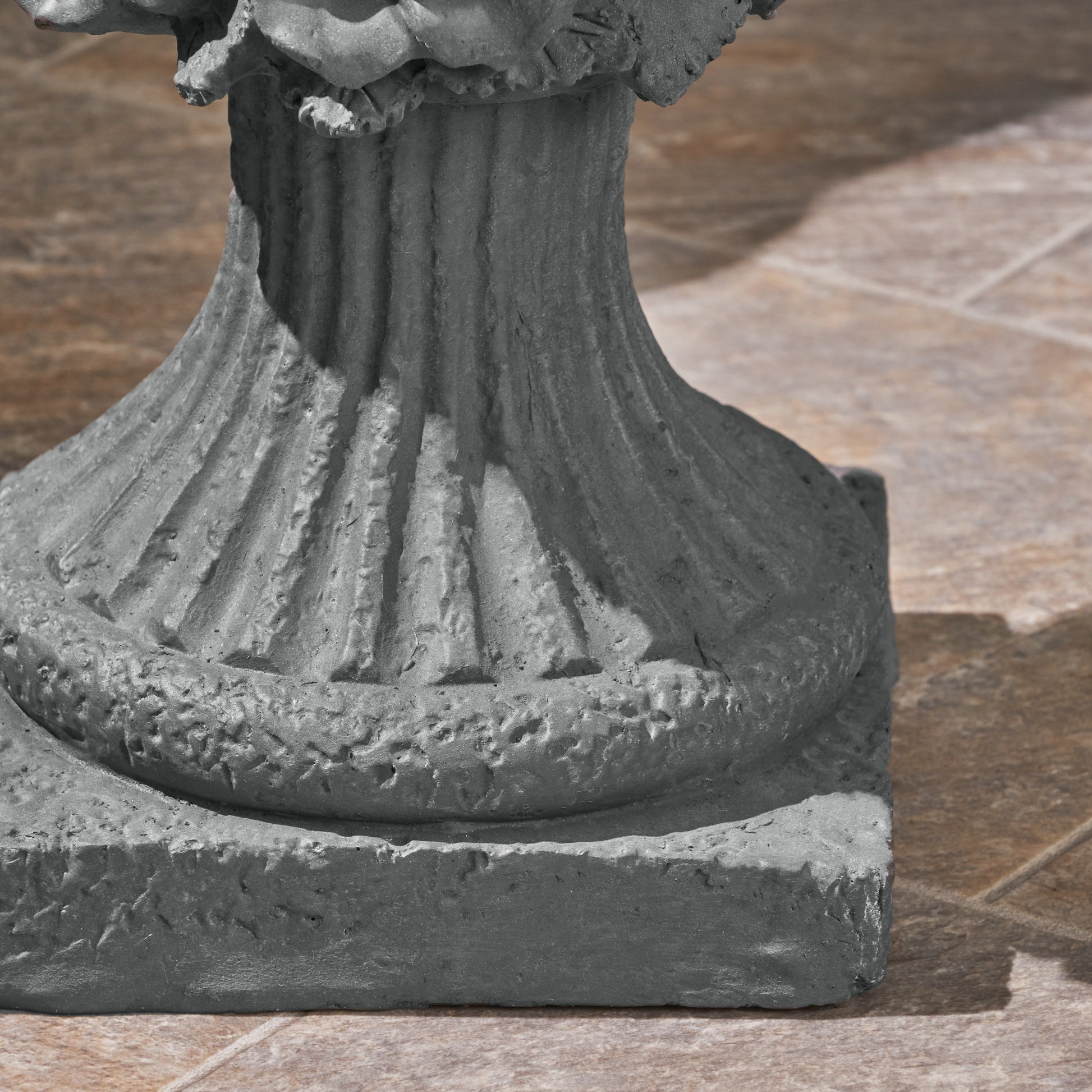 Gray concrete pedestal with fluted design and textured base