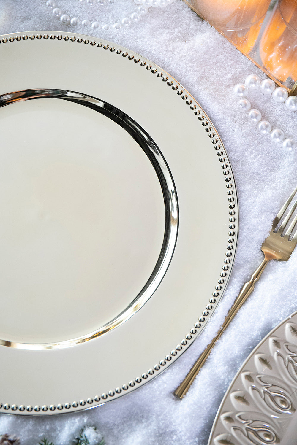 Silver charger plate with beaded rim and reflective surface