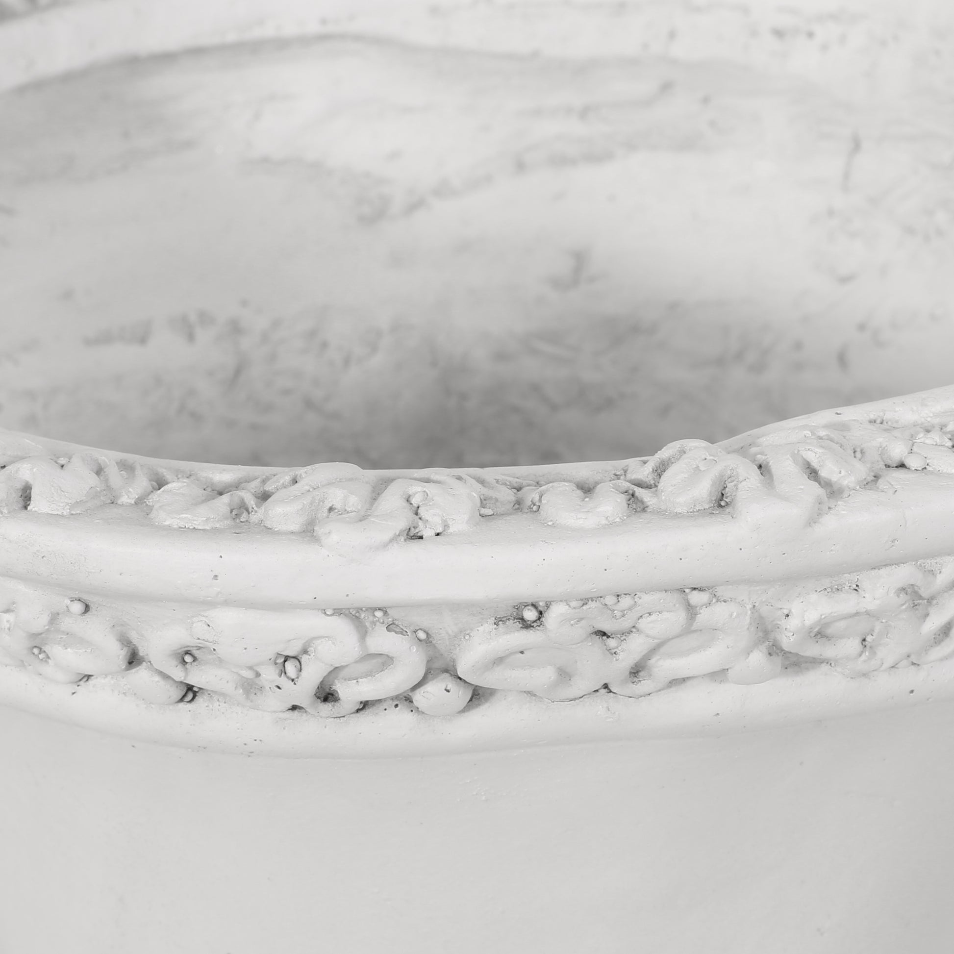 Antique white ceramic planter with embossed floral detail around rim