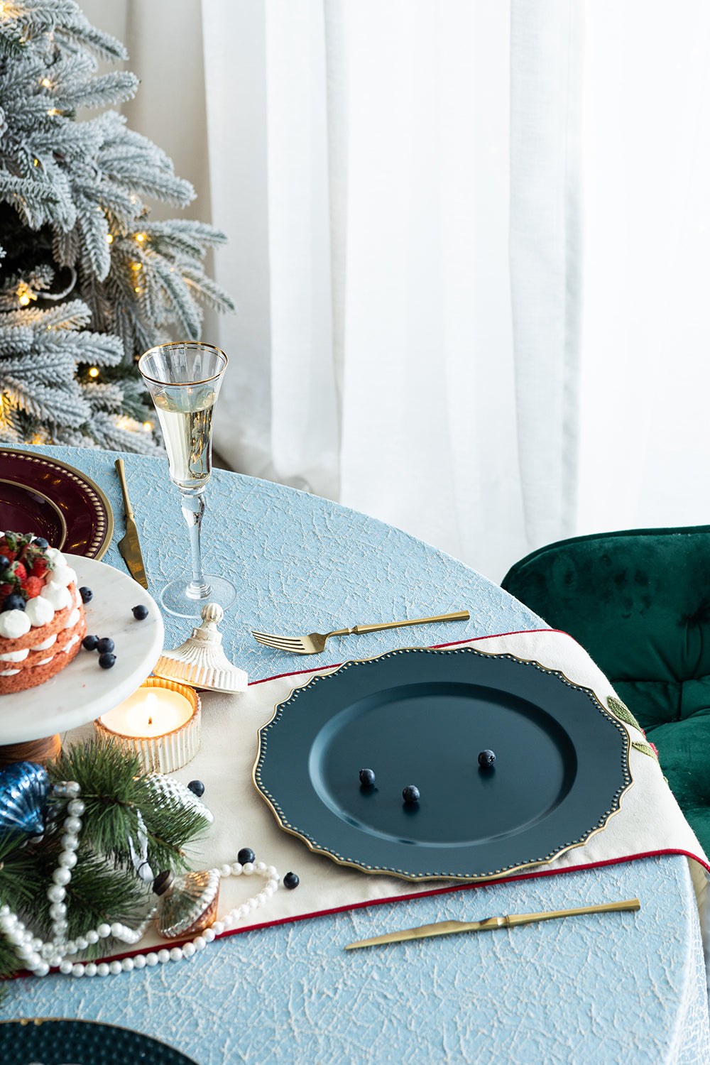 Decorative charger plate in deep teal with embossed gold rim perfect for elegant dining