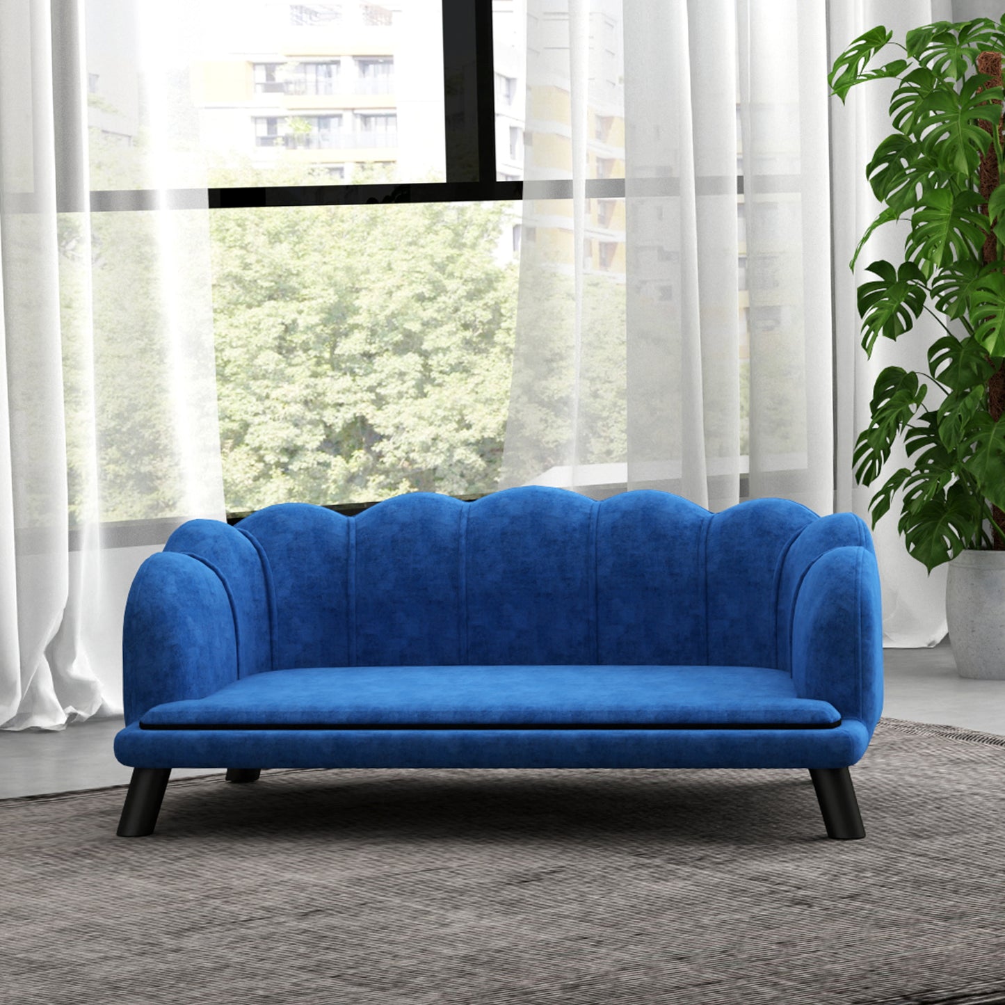 Velvet scalloped back blue sofa with black legs on a grey rug