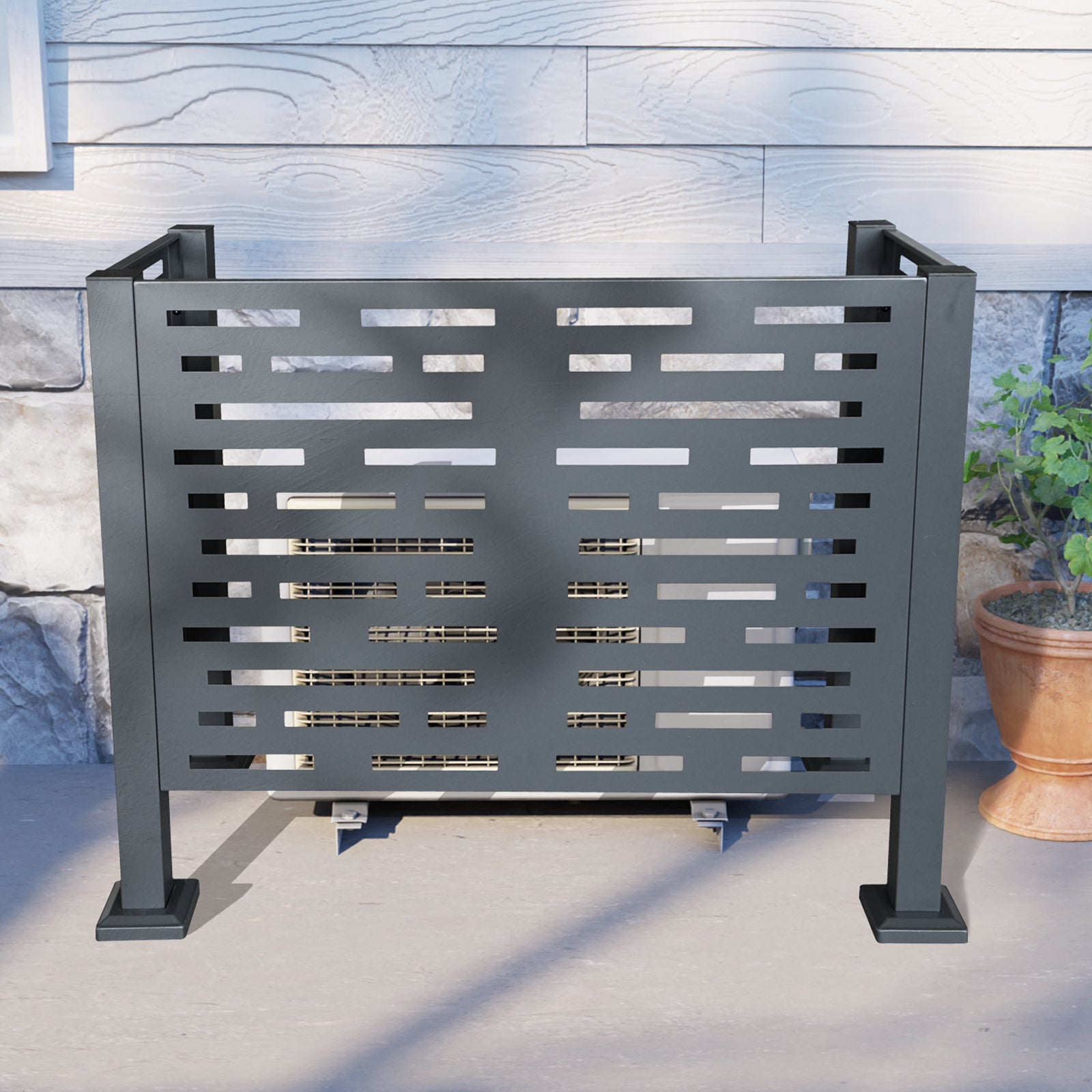 Charcoal metal air conditioner screen with decorative geometric cutouts protecting an outdoor unit