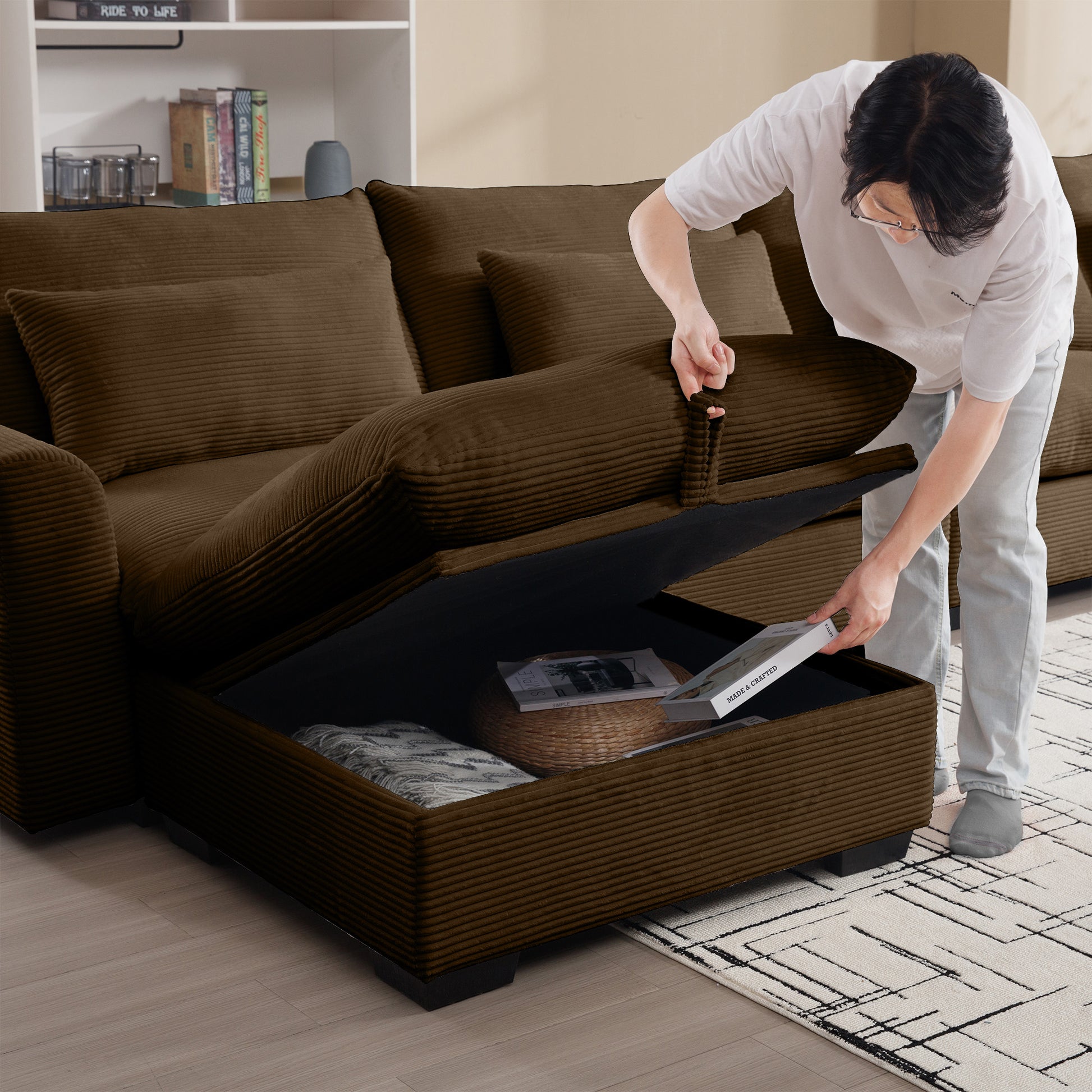 Brown corduroy sectional sofa with hidden storage compartment being accessed by a person