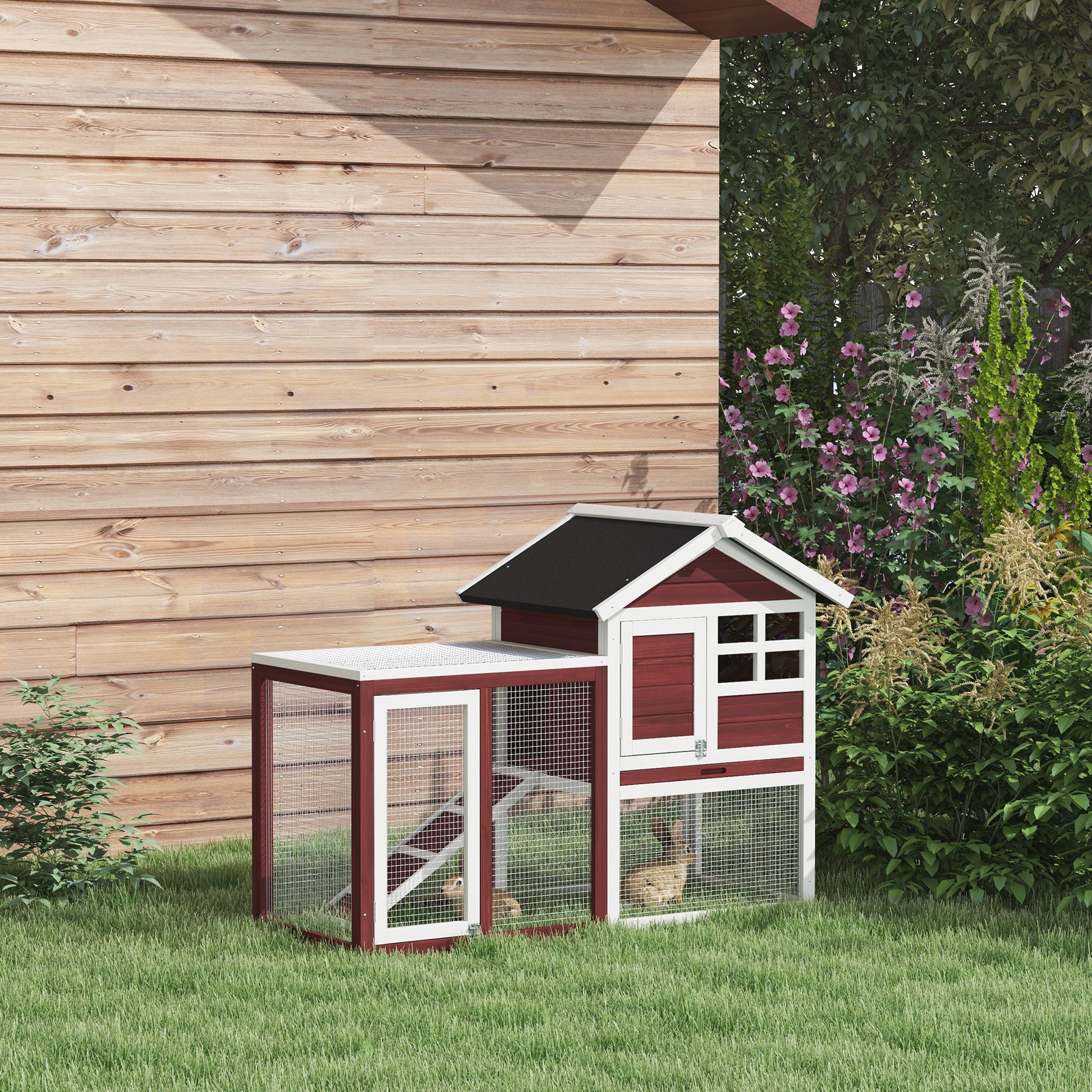 Twostory red wooden chicken coop with white trim and wire mesh panels housing small rabbits