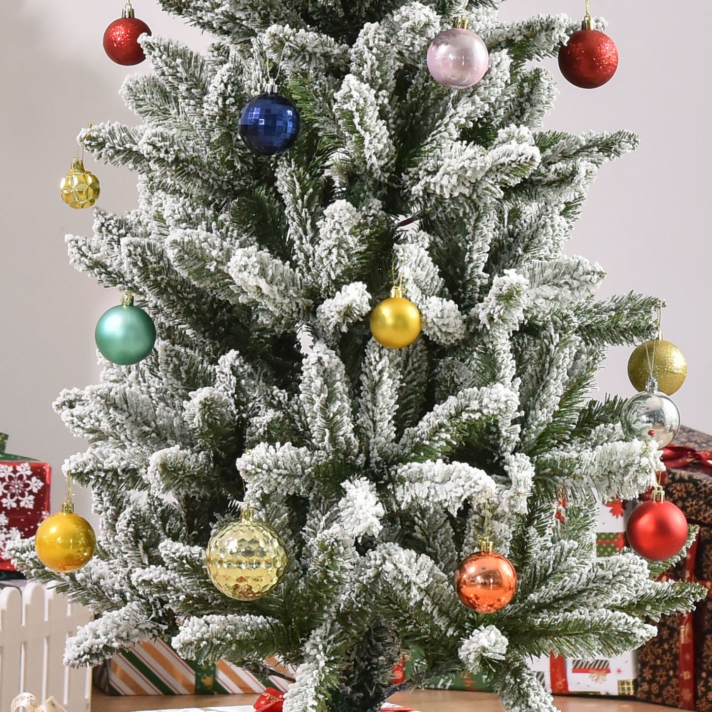 Frosted artificial christmas tree adorned with red glitter baubles