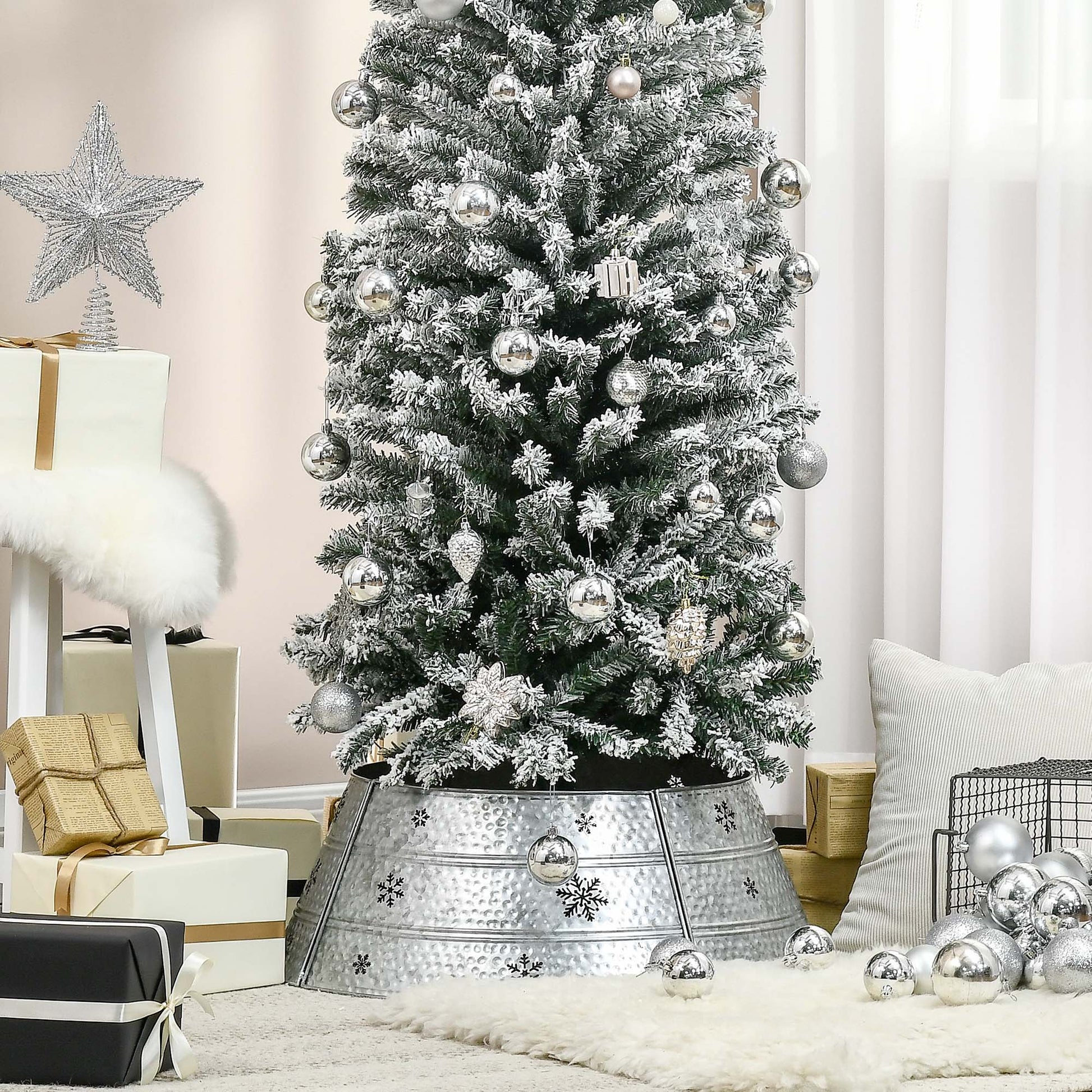 Frosted flocked artificial Christmas tree with silver ornaments and snowflake tree skirt