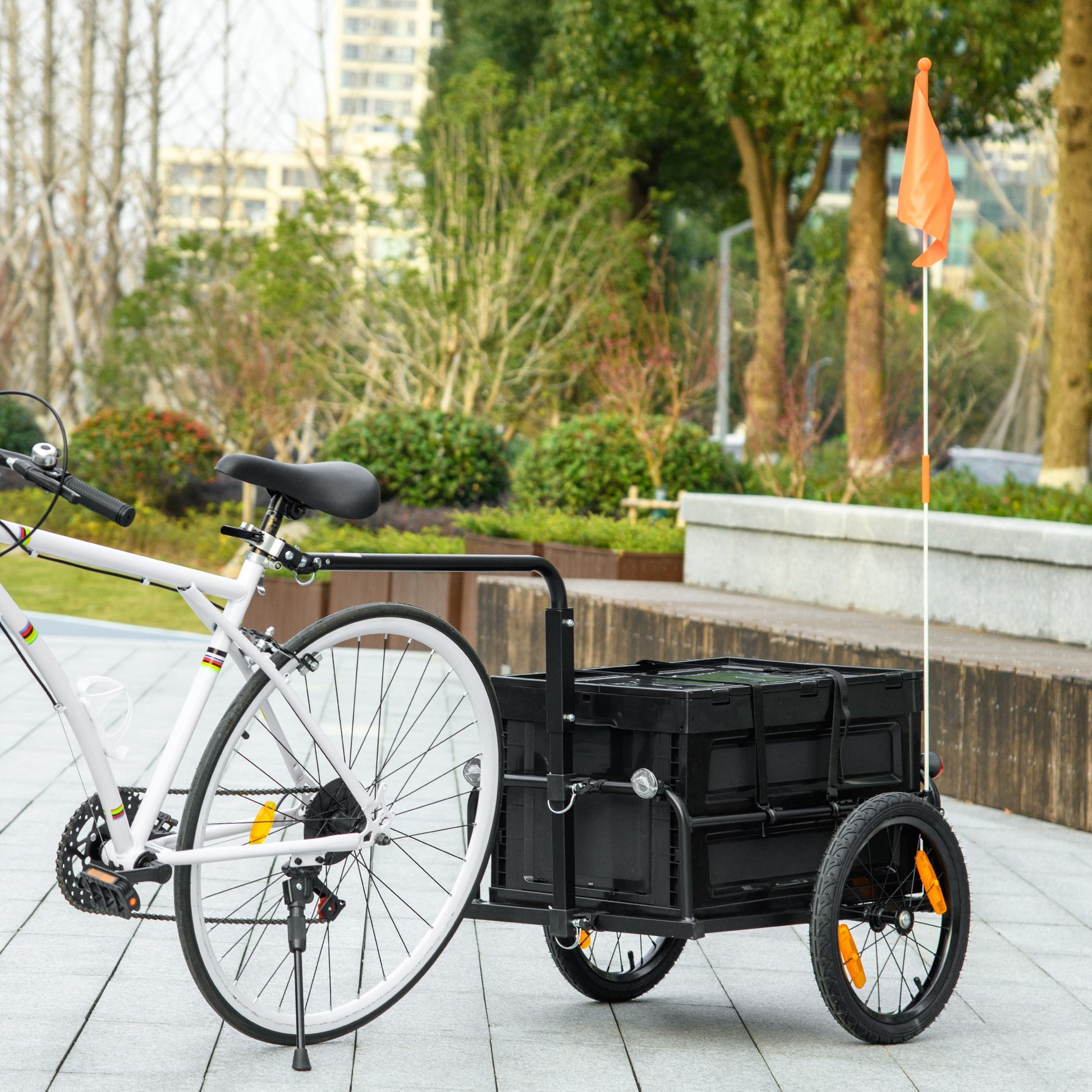 White bicycle with black cargo trailer attached ready for hauling groceries