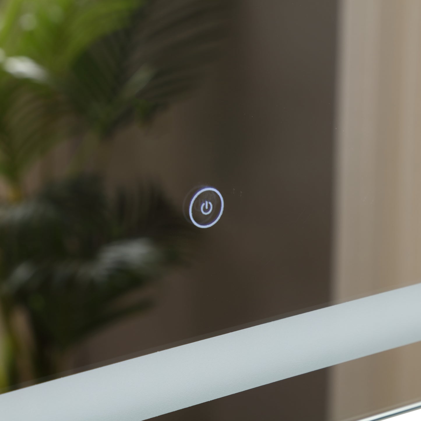 Illuminated power button on a modern bathroom mirror with frosted edge