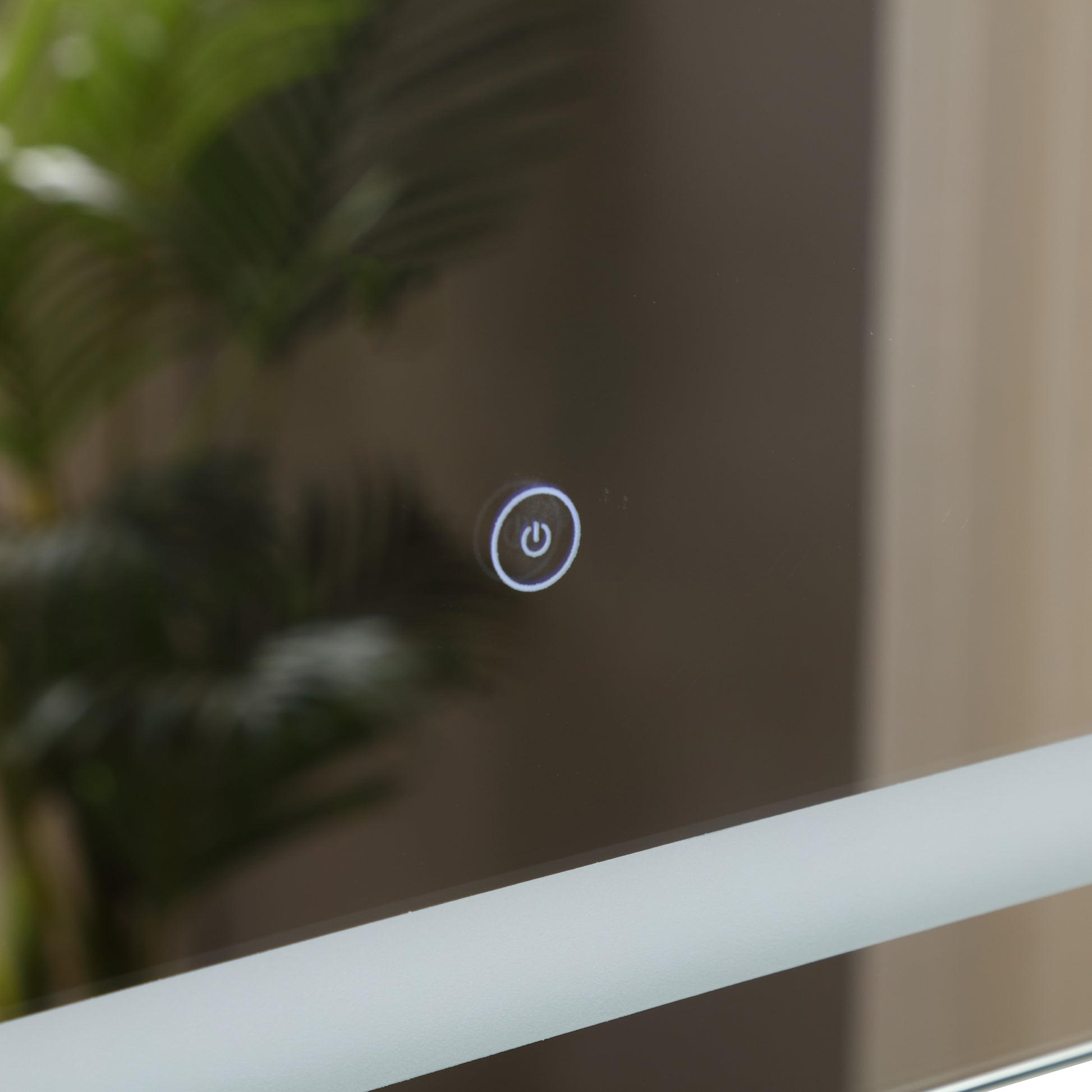Illuminated power button on a modern bathroom mirror with frosted edge