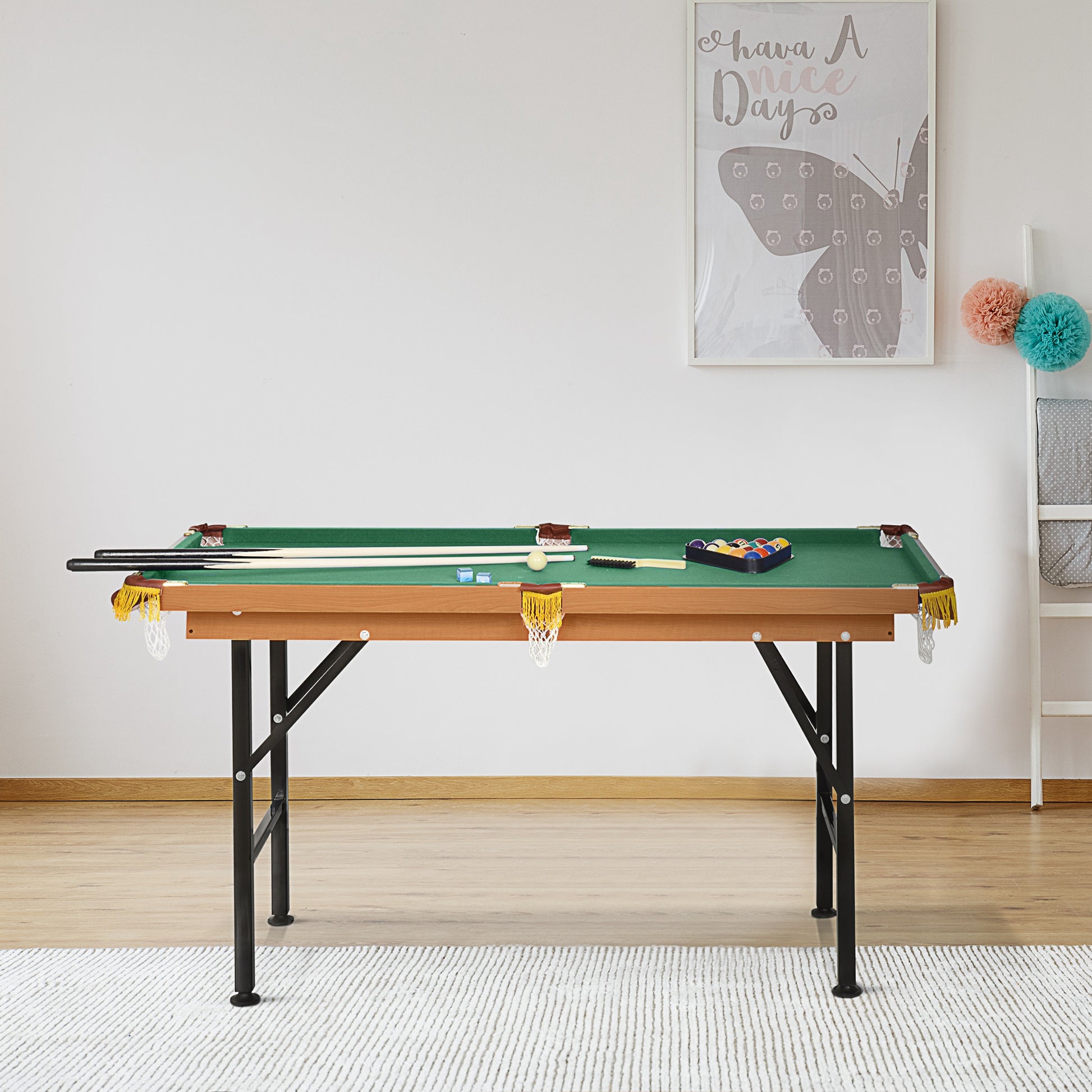 Green felt pool table with wooden frame and black legs includes cues and balls