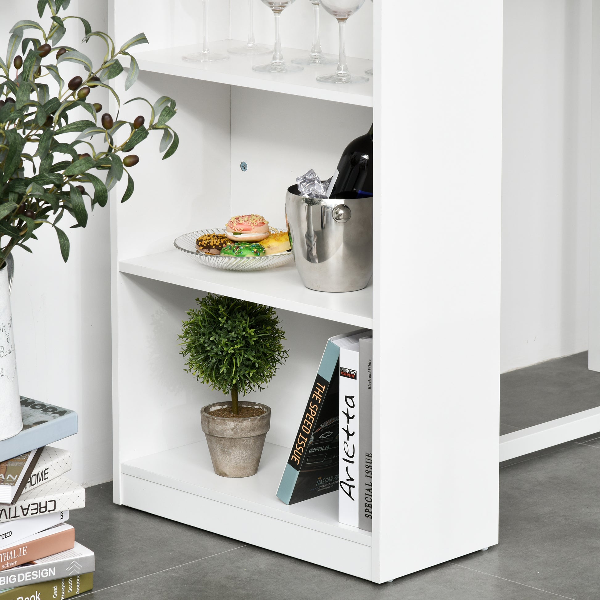 Elegant faux olive branch in a white vase on a shelf