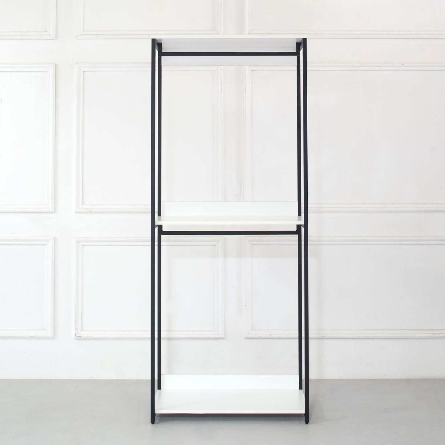 Minimalist black metal clothing rack with three white shelves