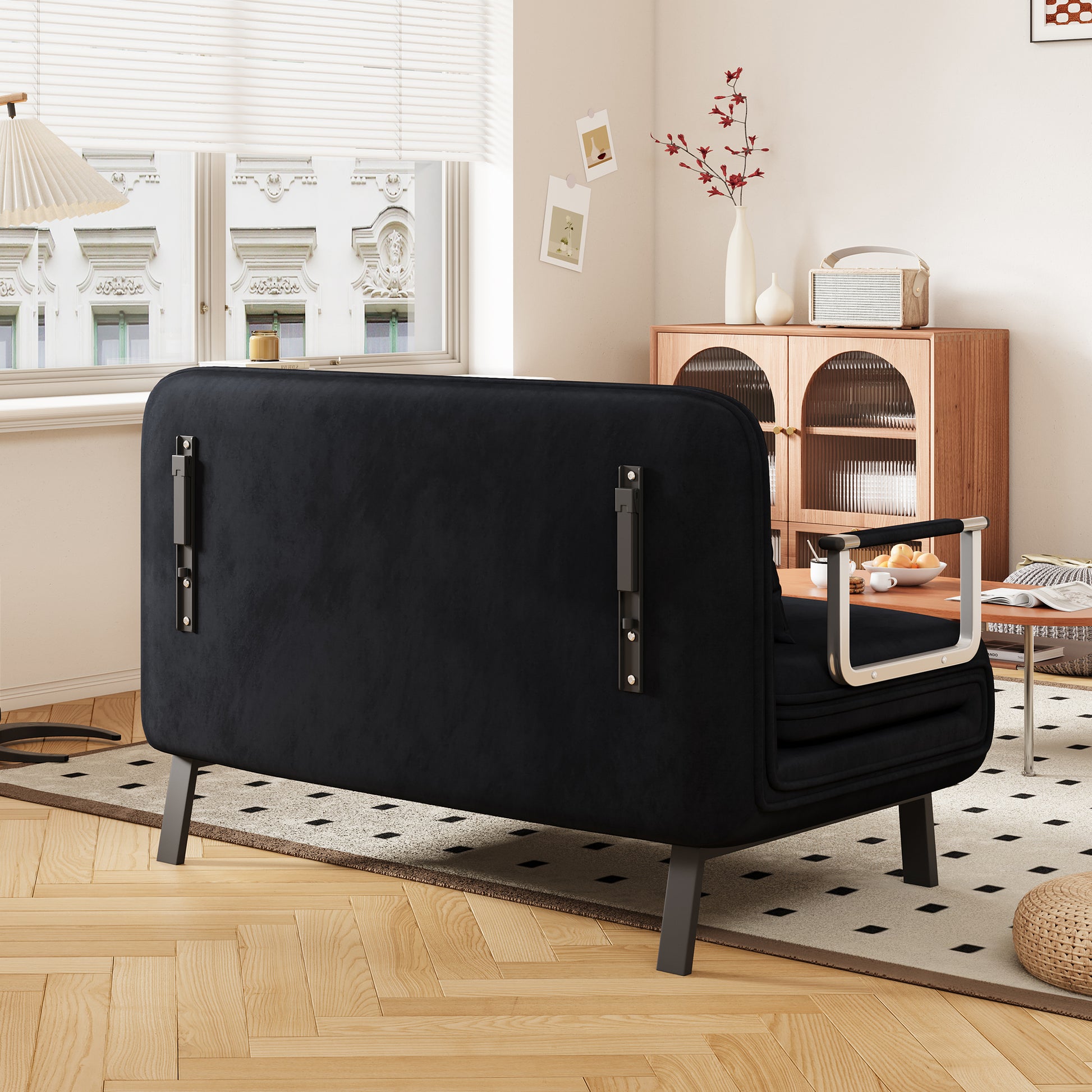 Black velvet convertible sofa with metal armrests and legs ideal for small living spaces