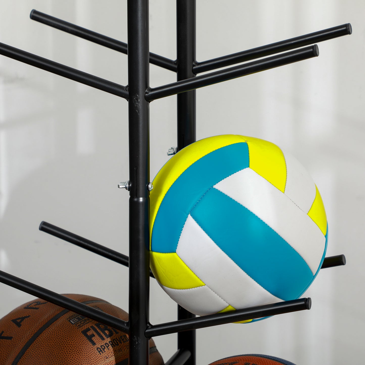 Bright yellow blue and white volleyball with stitched panels on a black stand
