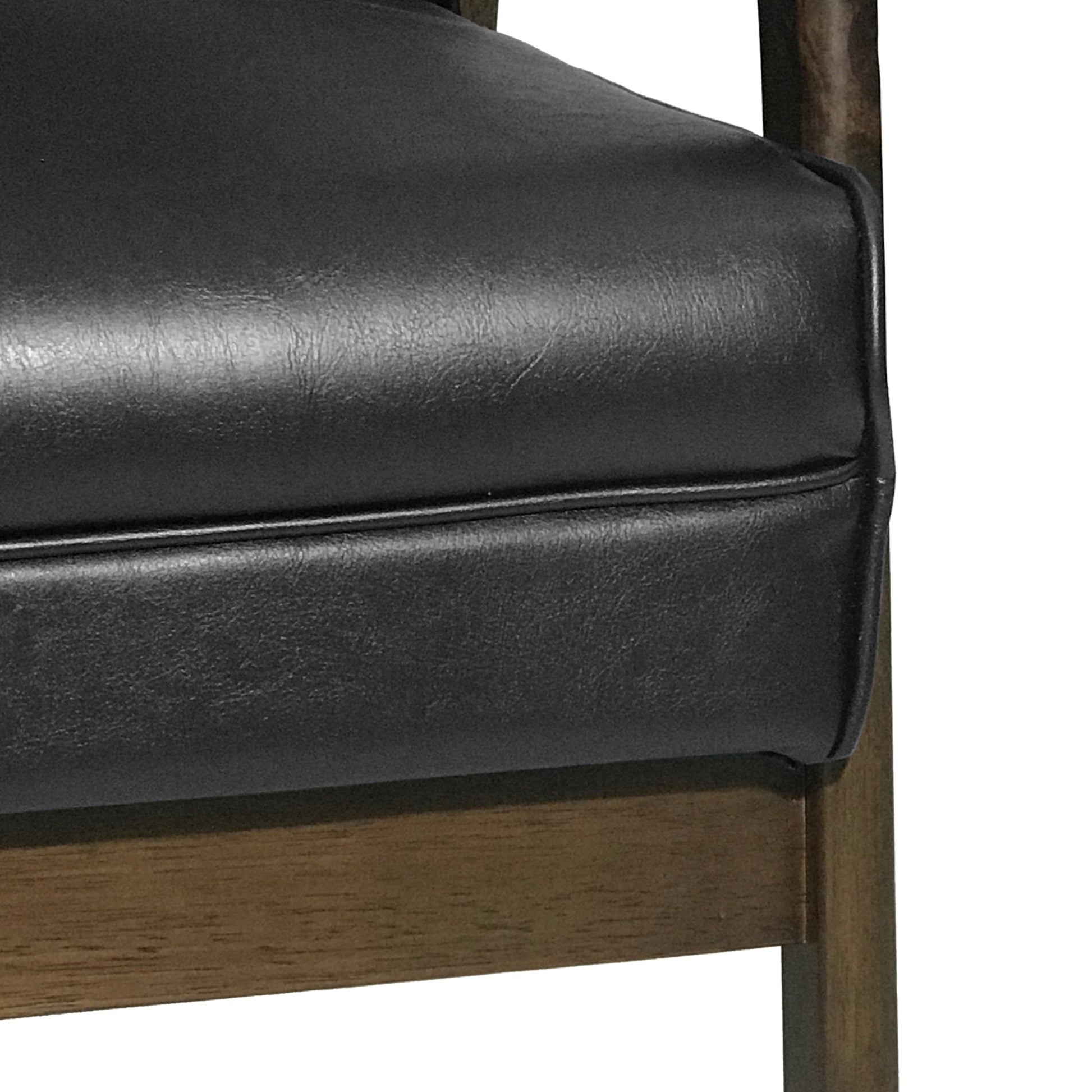 Closeup of a black faux leather chair seat with visible stitching detail