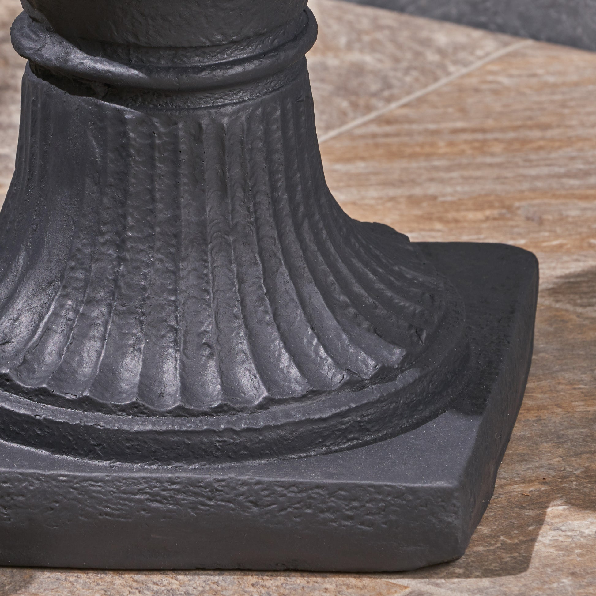 Detailed shot of a black cast iron pedestal base with fluted texture