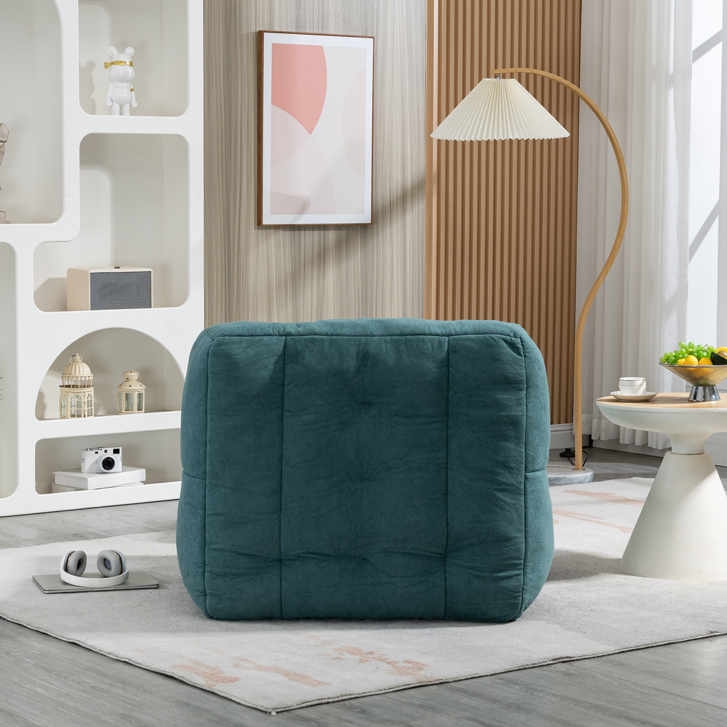 Teal velvet tufted ottoman on a rug providing comfortable seating