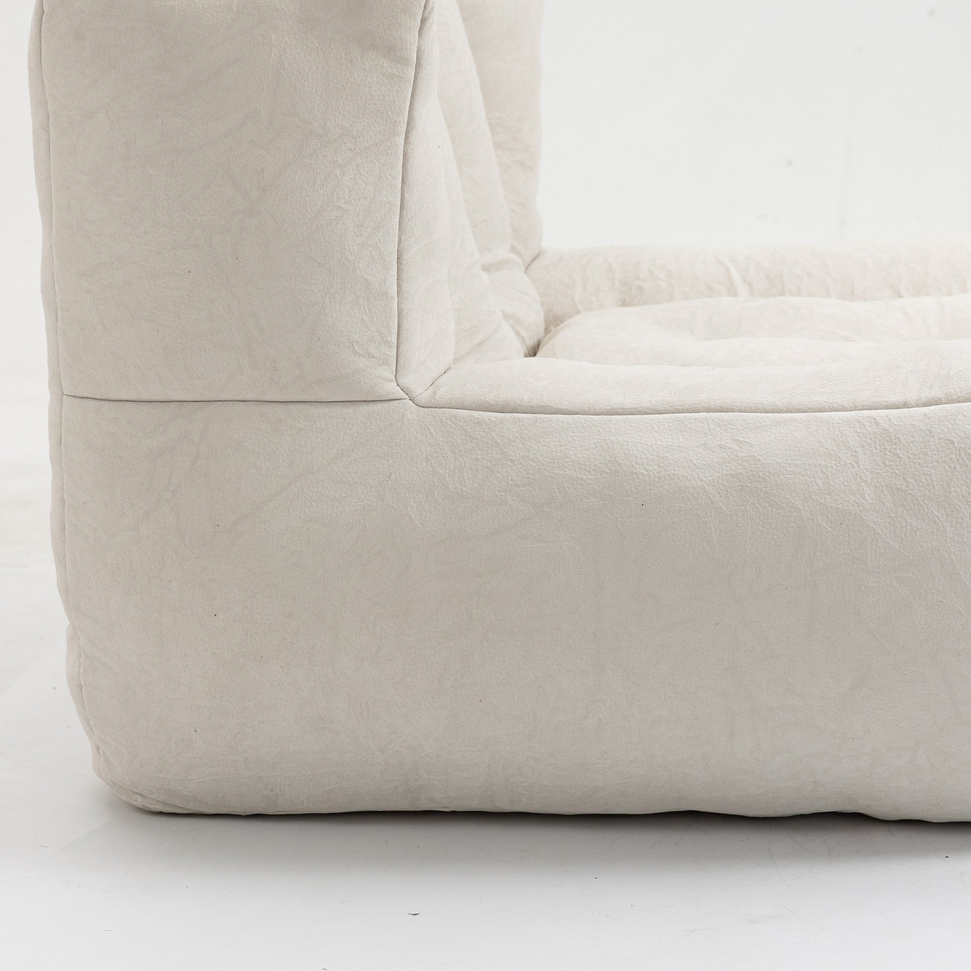 Closeup of a plush creamcolored boucle fabric armchair with soft rounded edges