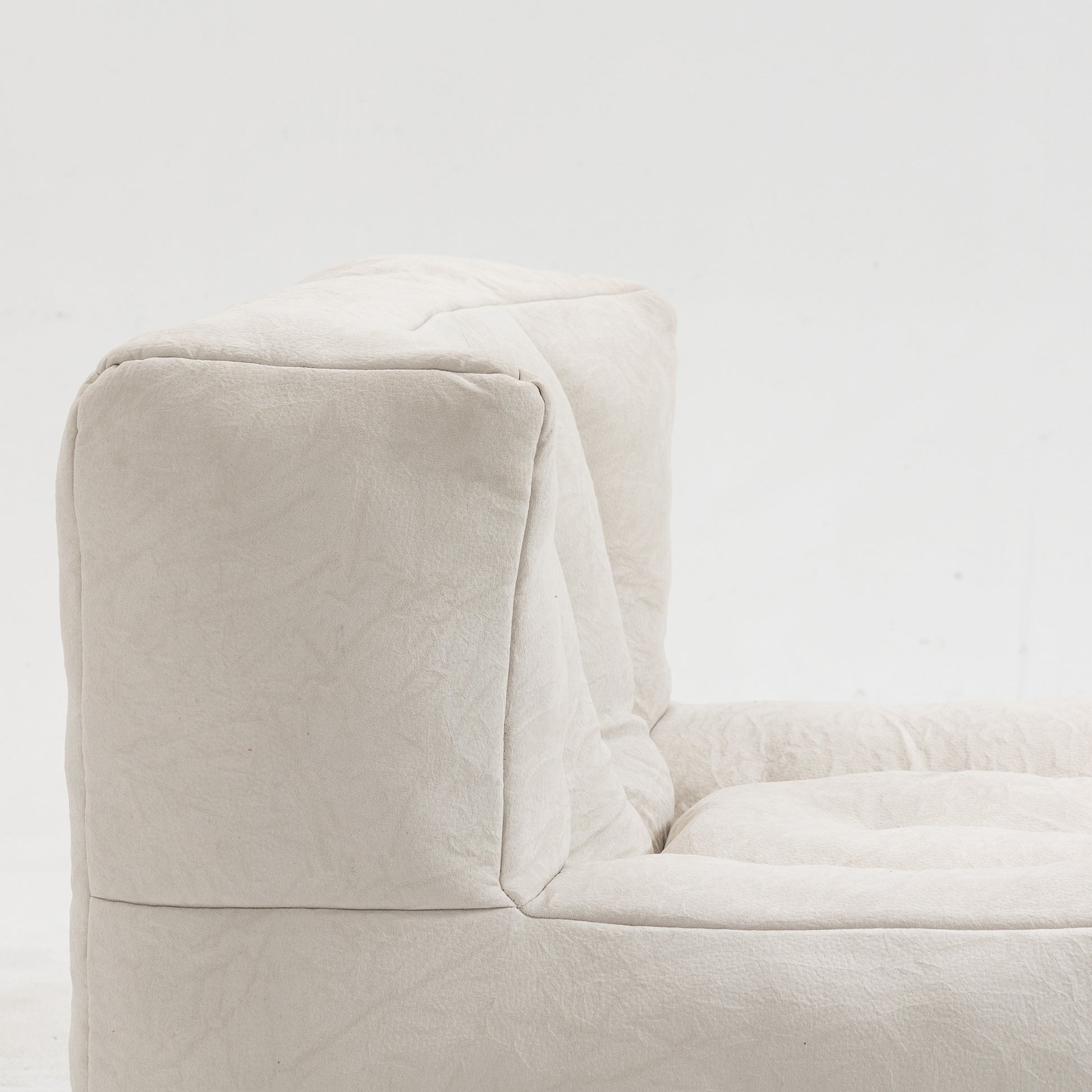 Closeup of a beige linen sofa with textured fabric and plush cushioning perfect for a modern living room