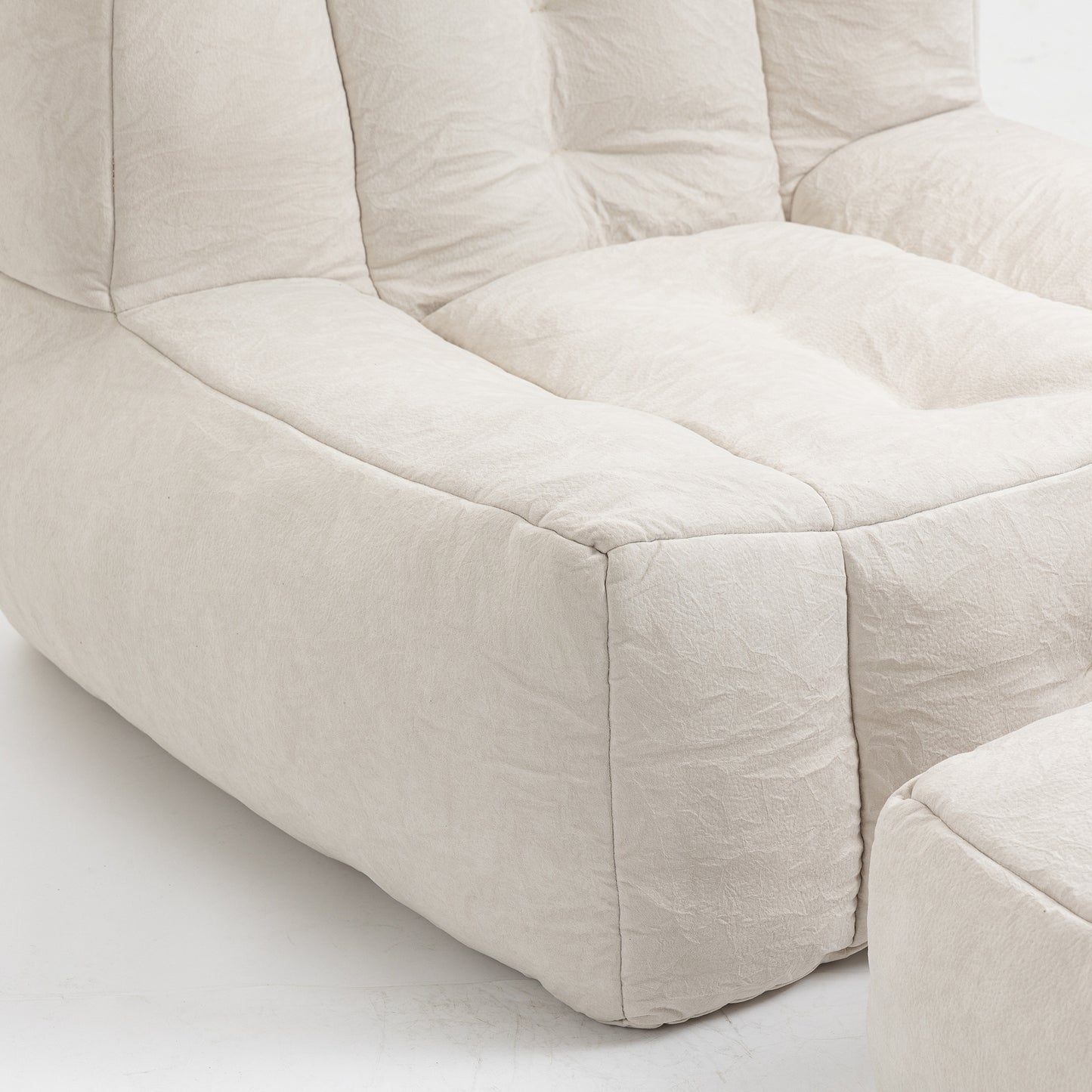 Cream linen tufted modular sofa section with button details and matching ottoman