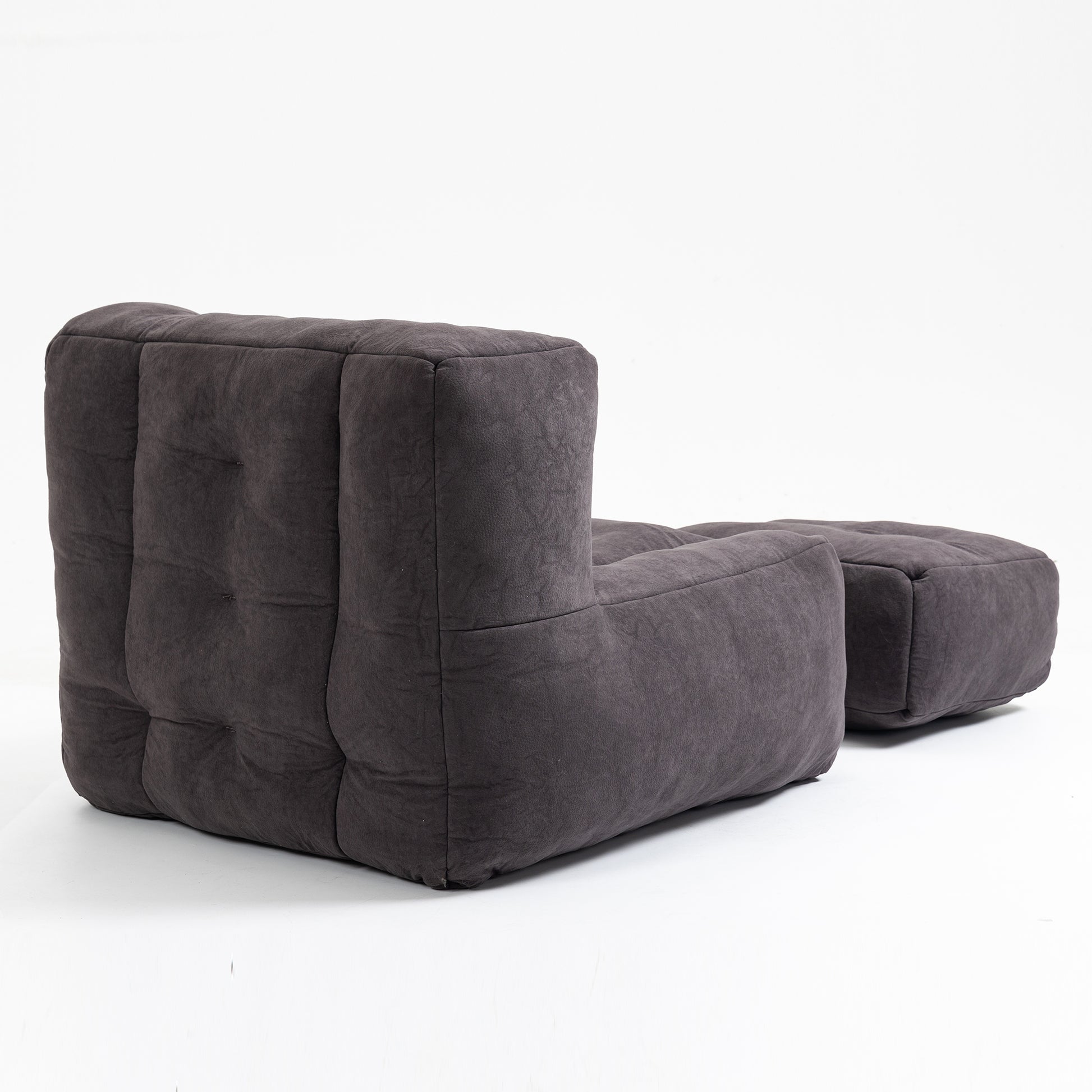Dark gray tufted fabric modular sofa section with attached ottoman