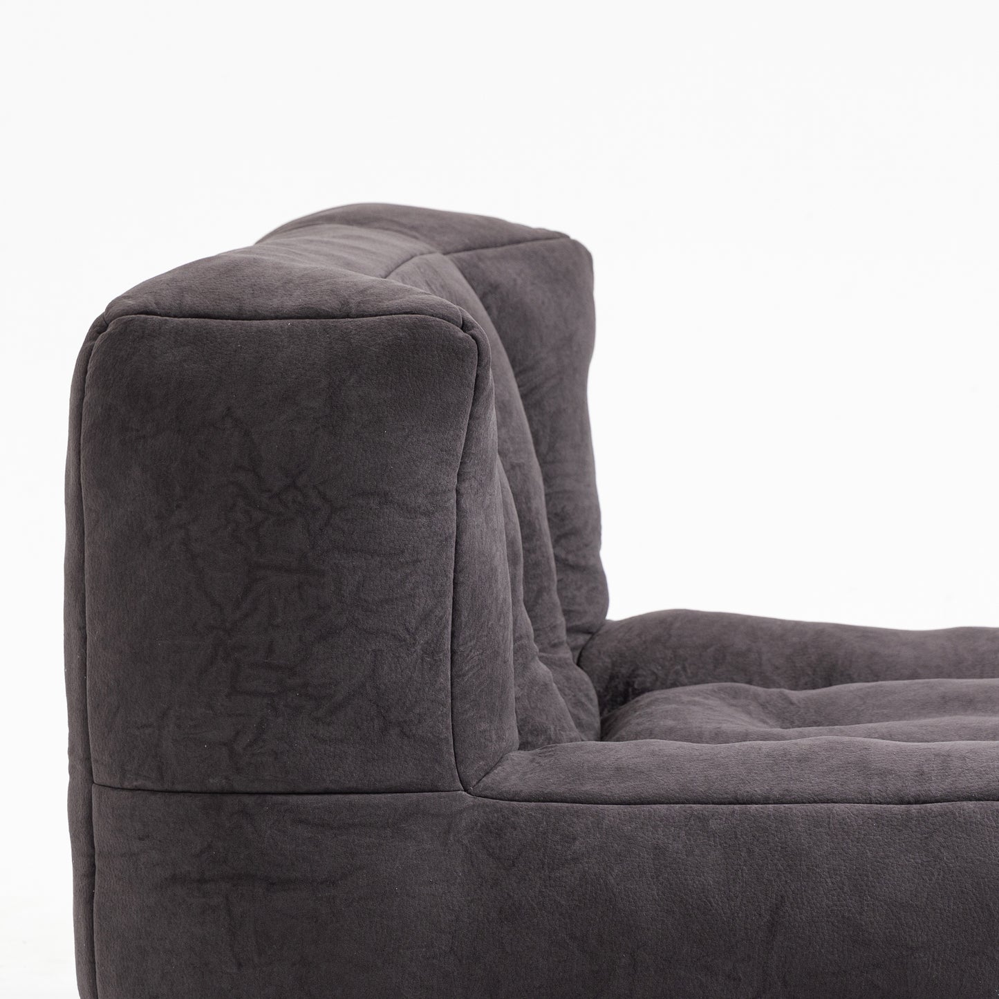 Closeup of plush dark grey velvet armchair corner and seat cushion