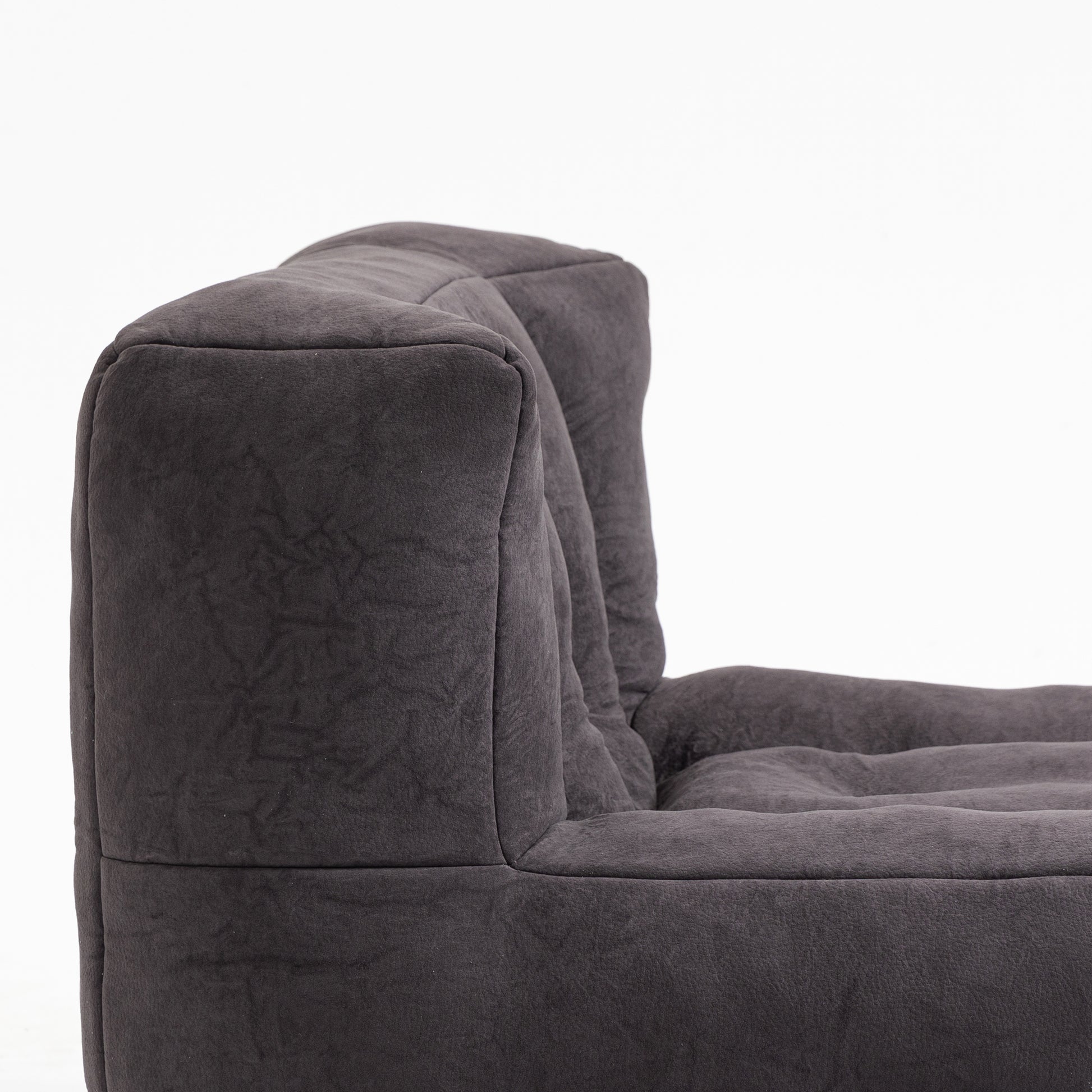Closeup of plush dark grey velvet armchair corner and seat cushion