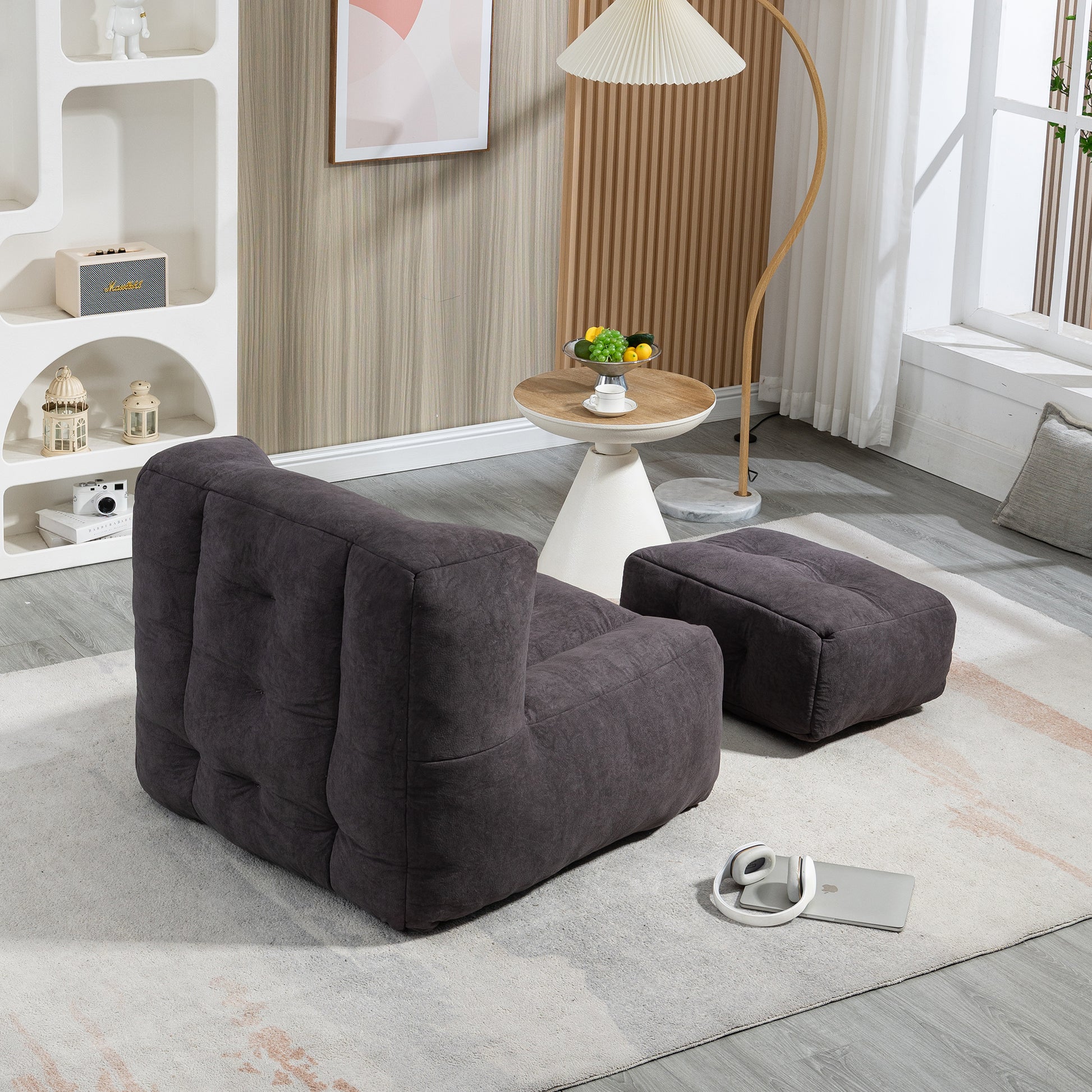 Dark gray tufted modular sofa and ottoman set in a modern living room
