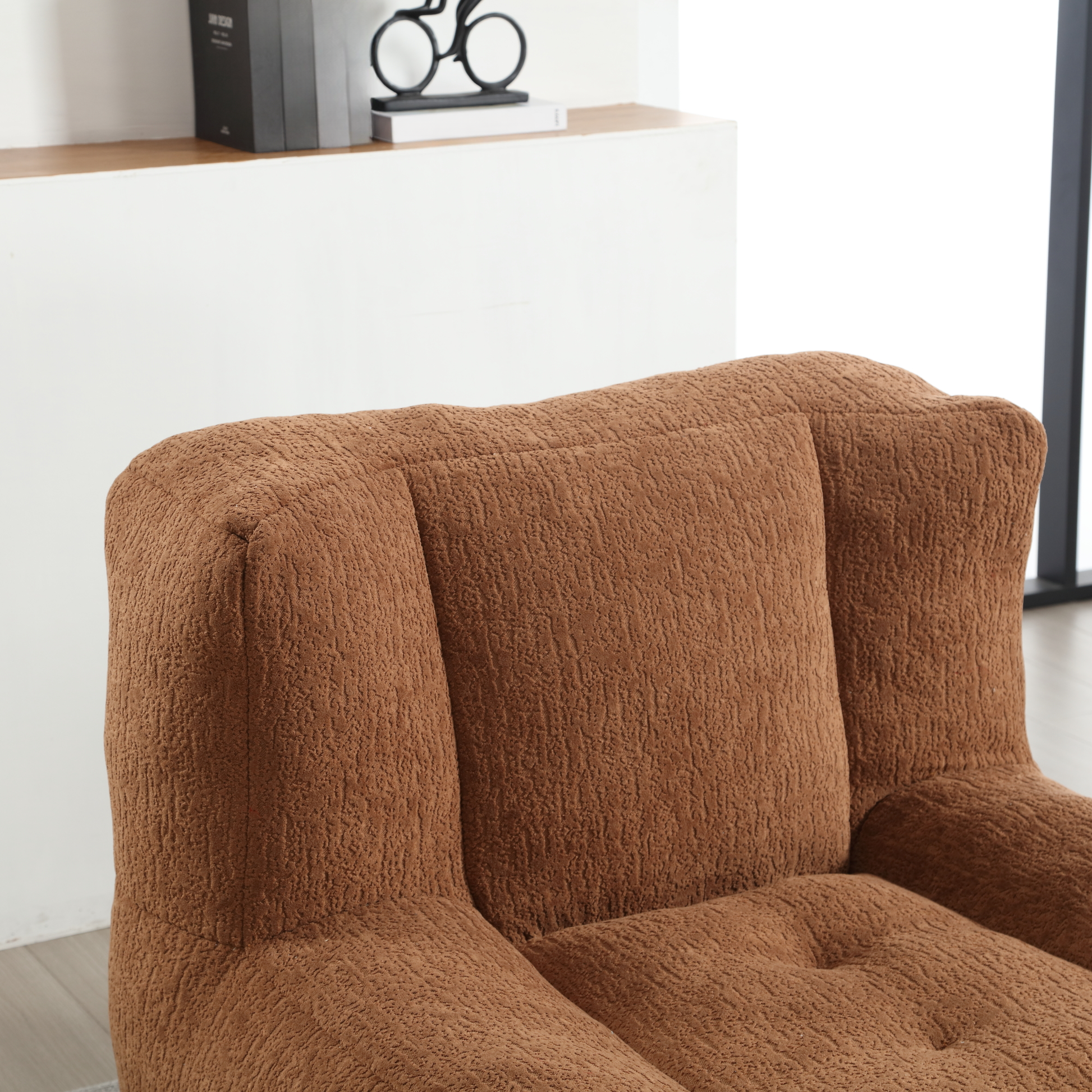 Closeup of plush brown armchair seat with textured fabric and deep tufting