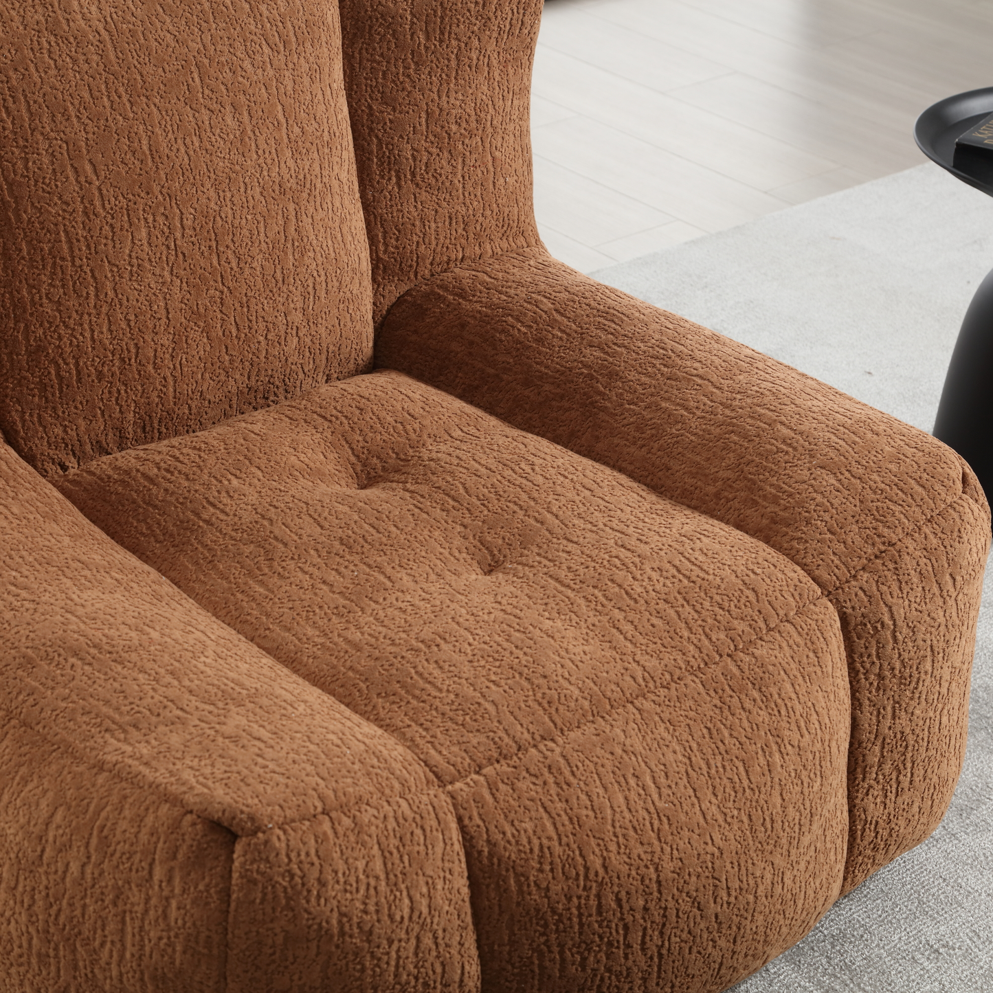 Closeup of a textured brown boucle fabric armchair seat with button tufting