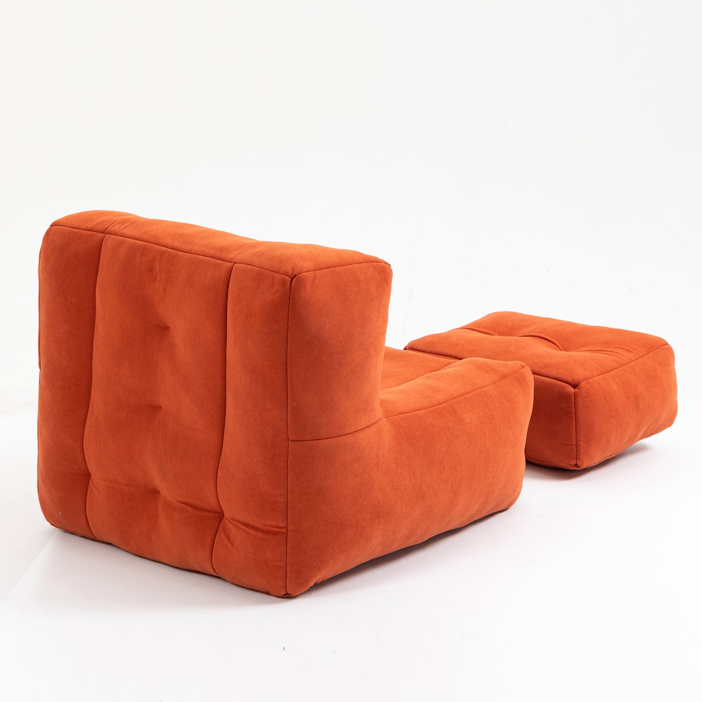 Plush burnt orange modular armchair with deep tufting and a matching ottoman