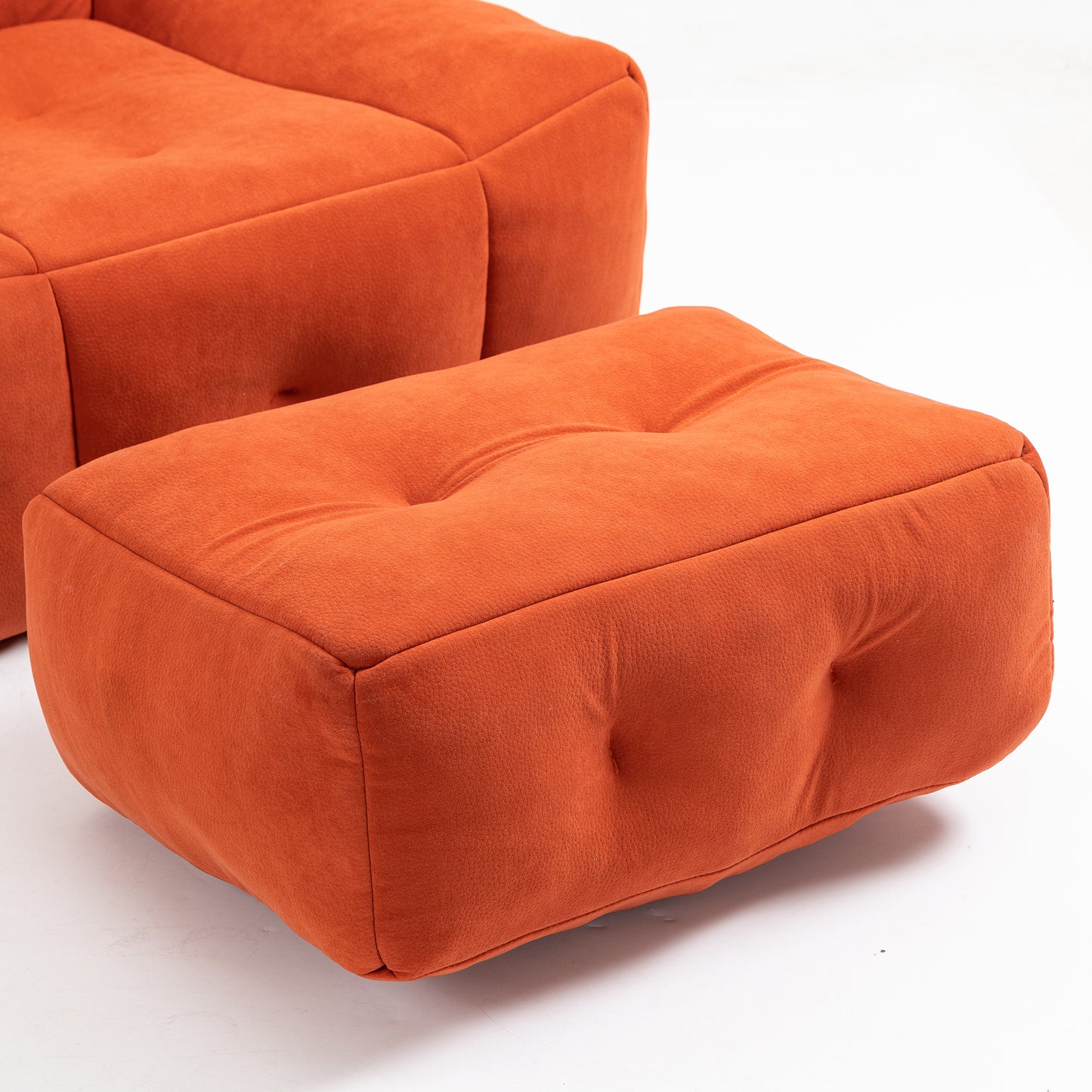 Orange velvet tufted ottoman with button accents perfect for adding comfort and style